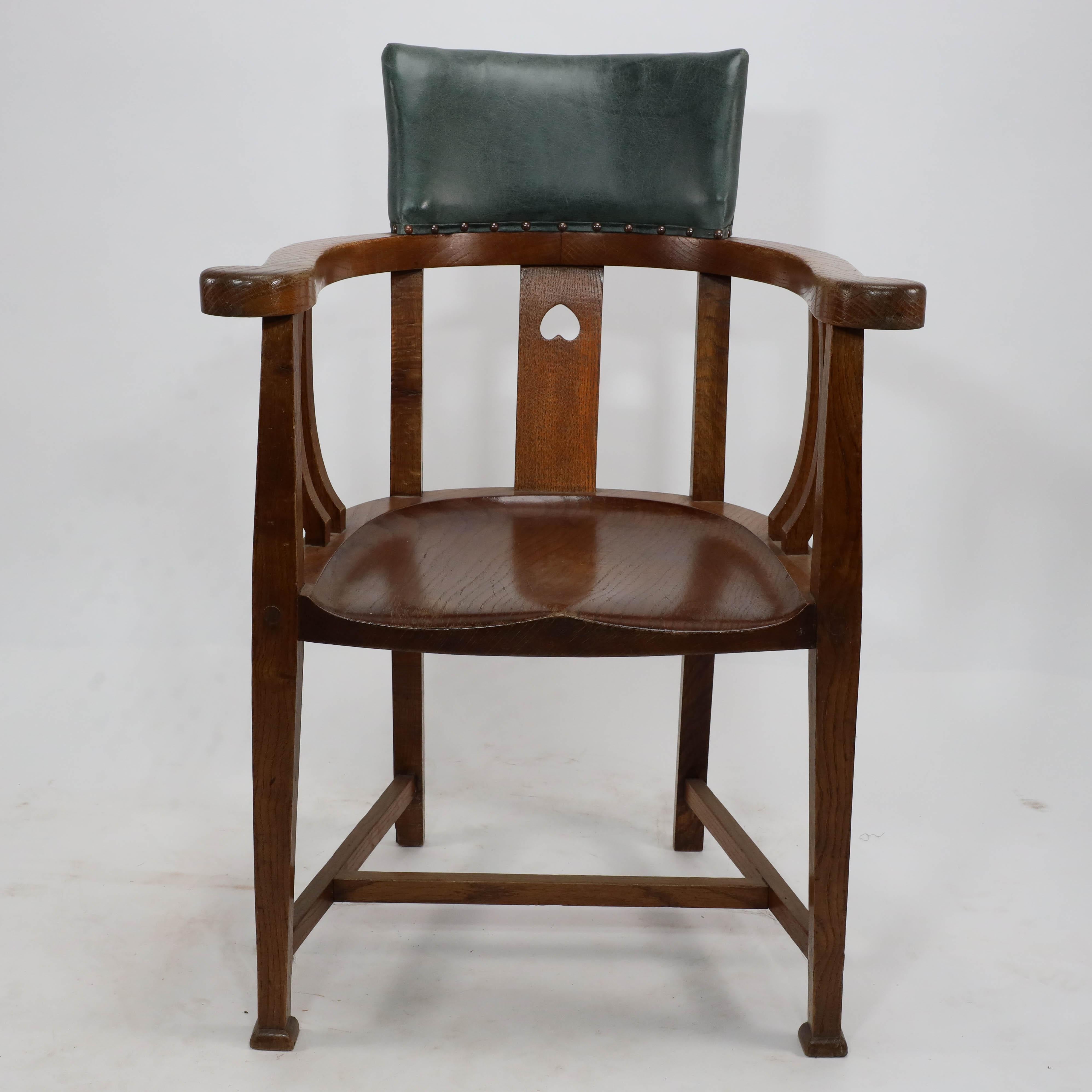 E A Taylor attribué. Chaise à baignoire en chêne de style Arts and Crafts, avec un seul cœur percé sur le support du dossier et des supports en forme sous les accoudoirs, le dossier en forme avec du cuir et une assise en forme.
