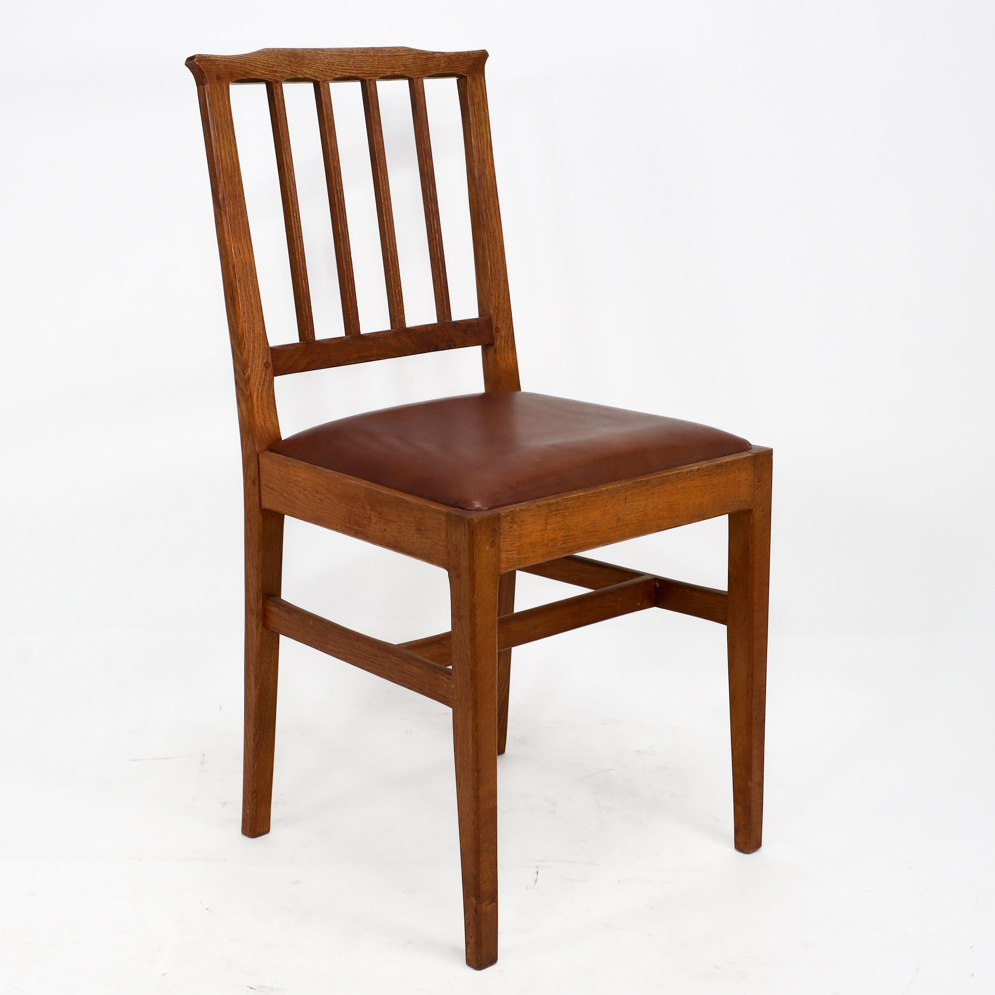 Edward Barnsley para la Oficina de Industrias Rurales. Conjunto de seis sillas de comedor de roble de estilo Arts & Crafts con detalles achaflanados en los respaldos y bellotas talladas en las patas, con asientos de cuero.
Alrededor de 1950.