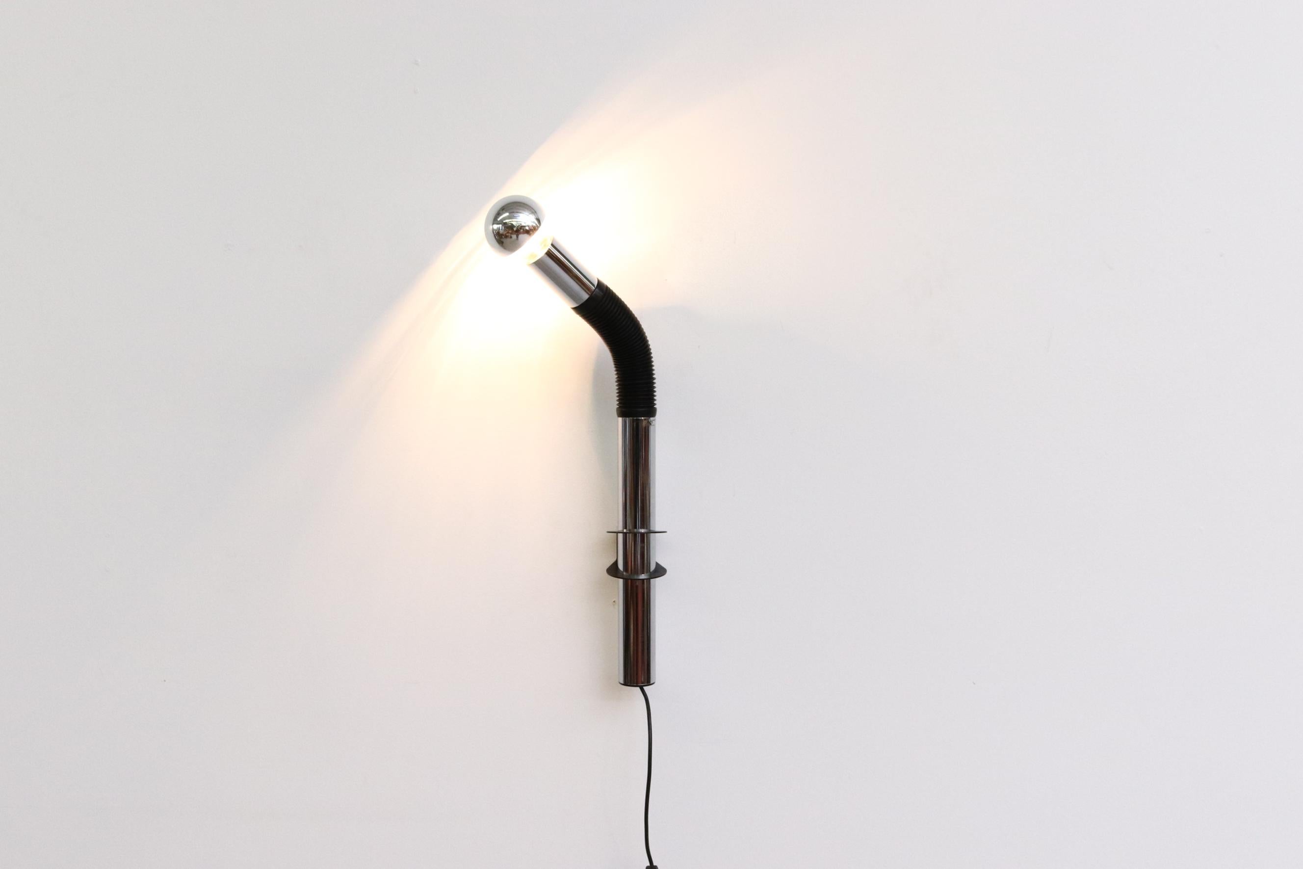 E. Bellini chrome and black goose neck wall mount spot lamp with adjustable height for Targetti Sankey, Italy, 1970s. Original manufacturer sticker, partially intact. Shown with a chrome tip bulb, not included. In original condition with some