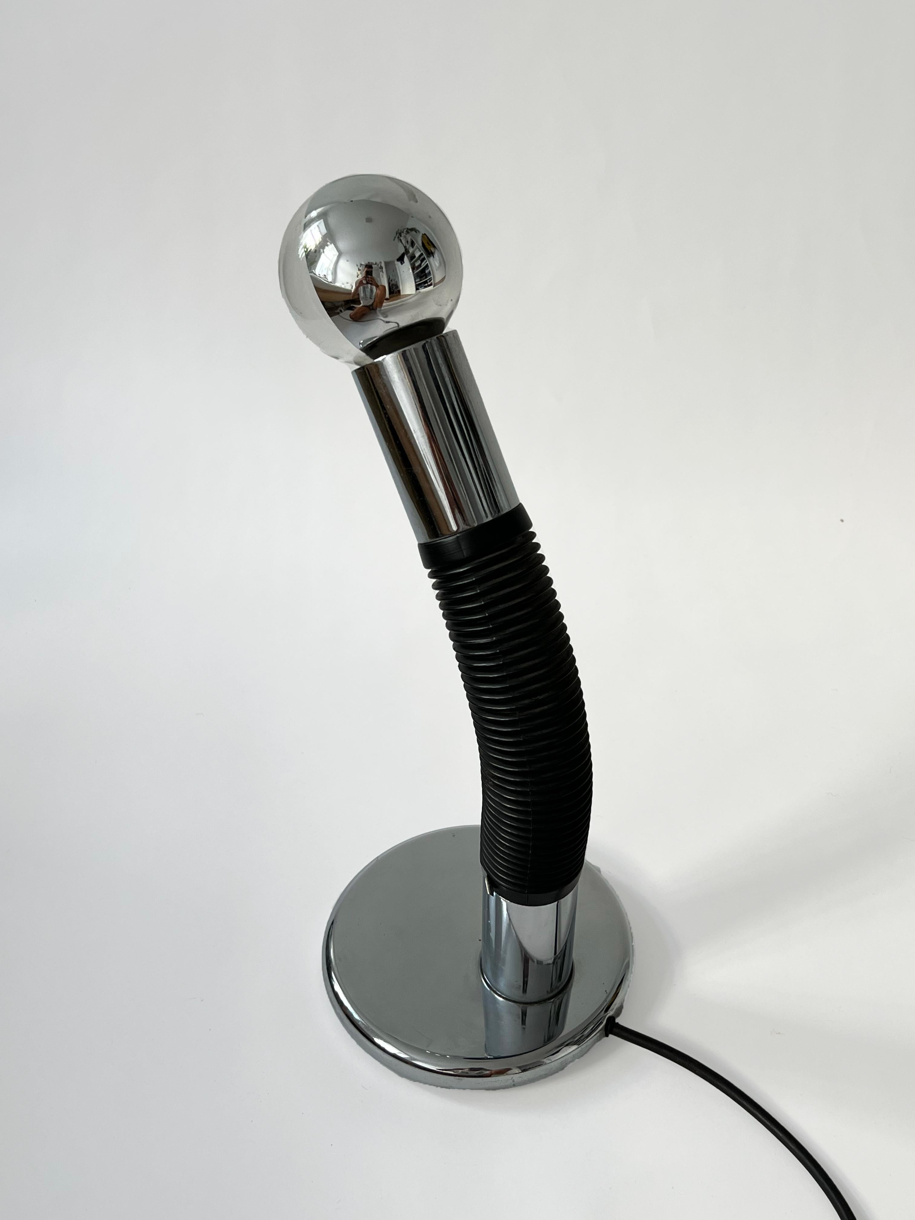 E. Bellini Elbow table lamp manufactured by Targetti Sankey in the 1970s. 
The lamp consists of a chrome-plated metal tube with a black rubber connector. The construction offers full flexibility.
 