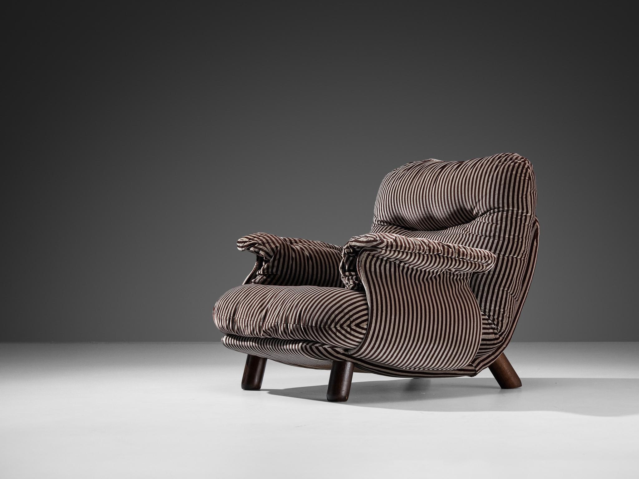 E. Cobianchi for Insa, lounge chair, fabric, stained wood, Italy, 1970s

An Italian bulky easy chair designed by E. Cobianchi. The lounge chair features a thick, tufted seat and backrest. The armrests are curved in an extravagant way, giving the