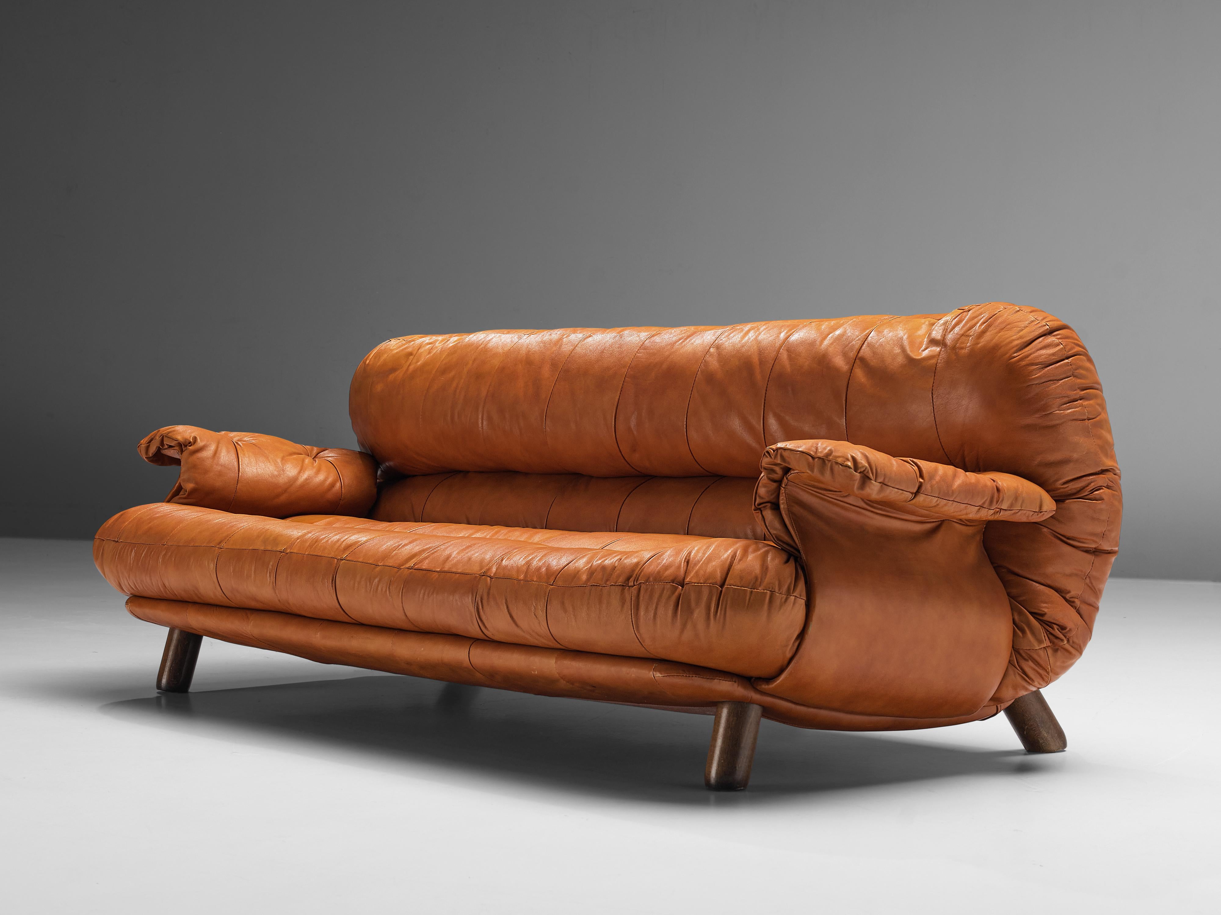 E. Cobianchi for Insa Italy, sofa, leather, wood, Italy, 1970s 

An Italian sofa in cognac leather by E. Cobianchi for Insa. The sofa features a thick, tufted seat and backrest. The armrests are curved in an extravagant way, giving the impression