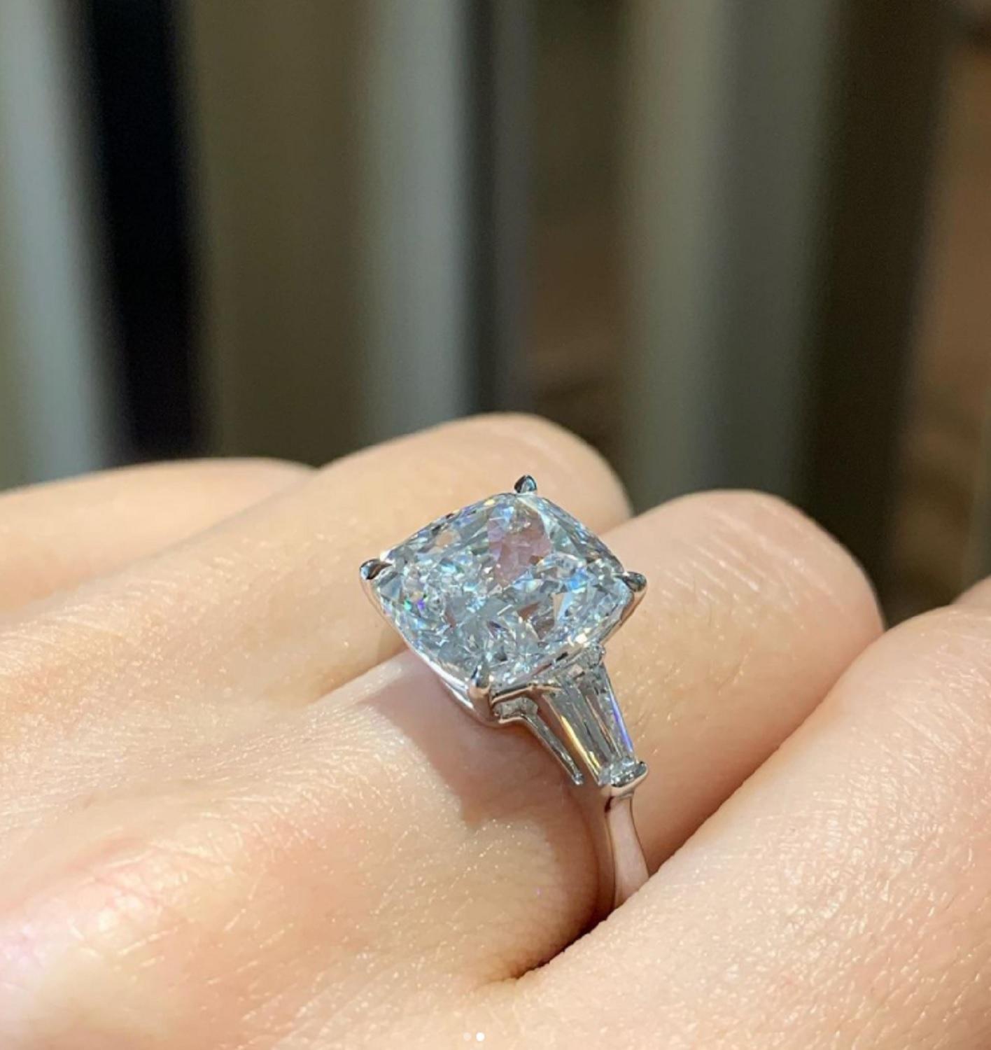 Ein exquisiter Ring, bestehend aus einem GIA-zertifizierten 5-Karat-Diamanten im Kissenschliff und zwei seitlich verjüngten Baguette-Diamanten. 
Die Fassung ist aus massivem 18 Karat Weißgold gefertigt.
 E FARBE
MAKELLOSE KLARHEIT