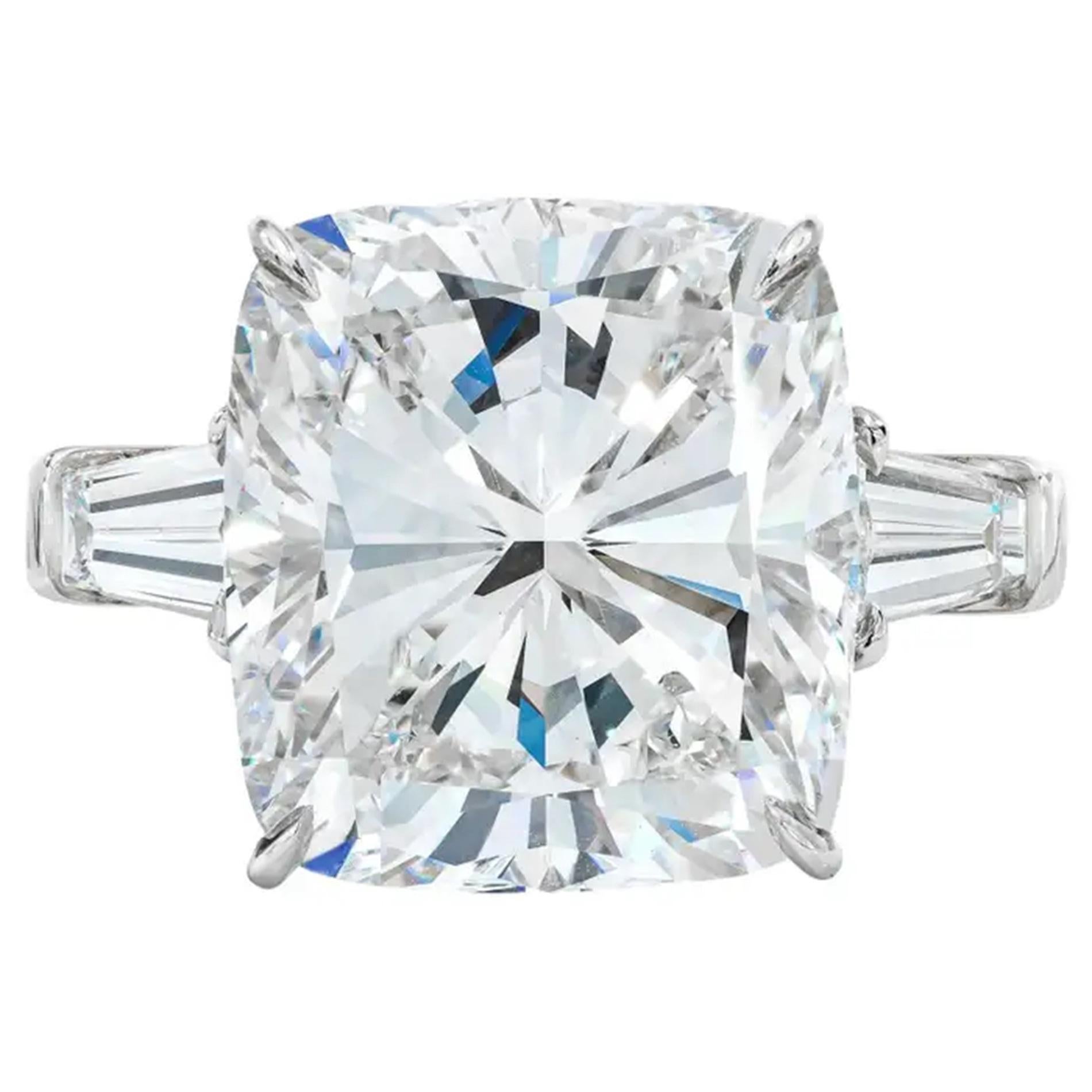 This exquisite ring showcases a dazzling 5.01 carat cushion cut diamond, set in elegant 18K white gold. 
The tapered baguette side diamonds add a sophisticated touch, framing the centerpiece with grace.

The diamond boasts an D color grade,