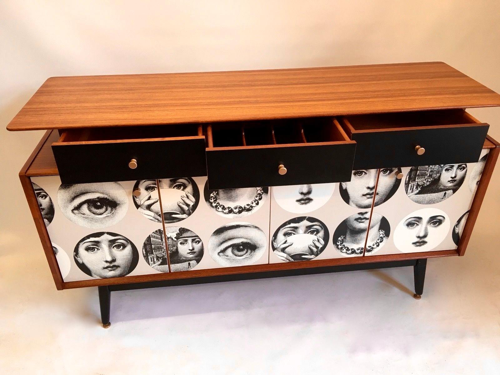 A beautifully made teak sideboard from 1958. The sideboard has been cleaned, sanded and oiled by hand. A wonderfully figured top section holding three drawers which float above a double cupboard below. Drawer fronts are in Black laminate (not
