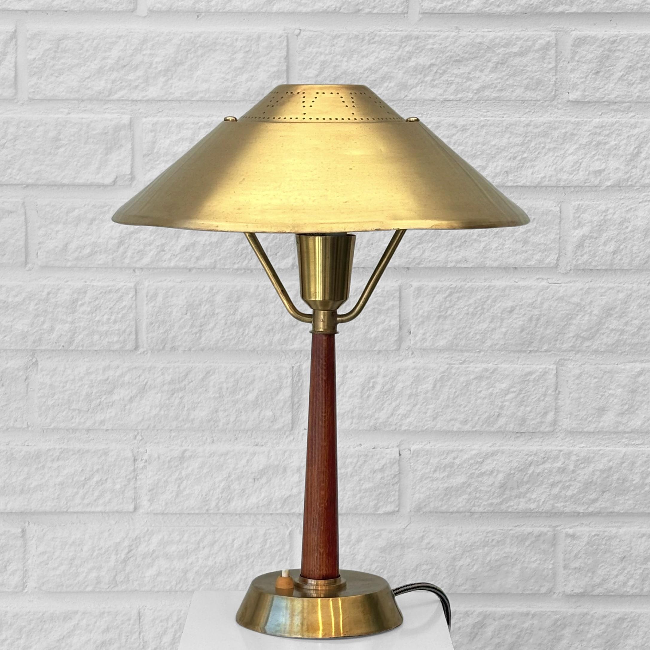 Rare lampe de table moderniste, modèle 568, produite par le fabricant suédois E. Hansson & Co. à Malmö dans les années 1940. La lampe présente un abat-jour en laiton en forme de disque magnifiquement perforé, soutenu par une élégante colonne en