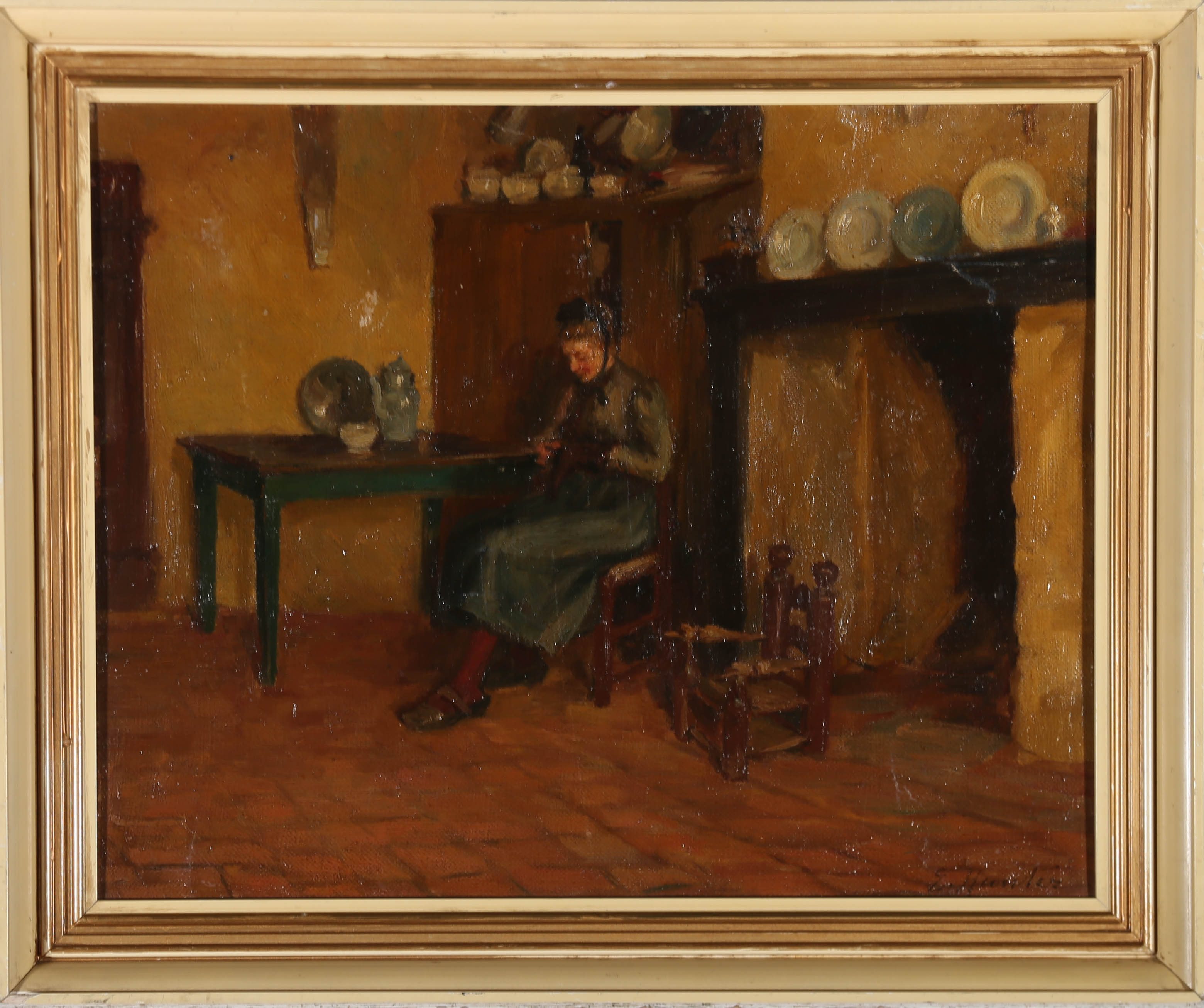 A charming early 20th Century interior scene in impressionistic oil. The scene shows a woman in Edwardian dress, sitting in a rustic cottage kitchen by the fireplace, darning an item of clothing. A small wooden children's chair sits next to her,