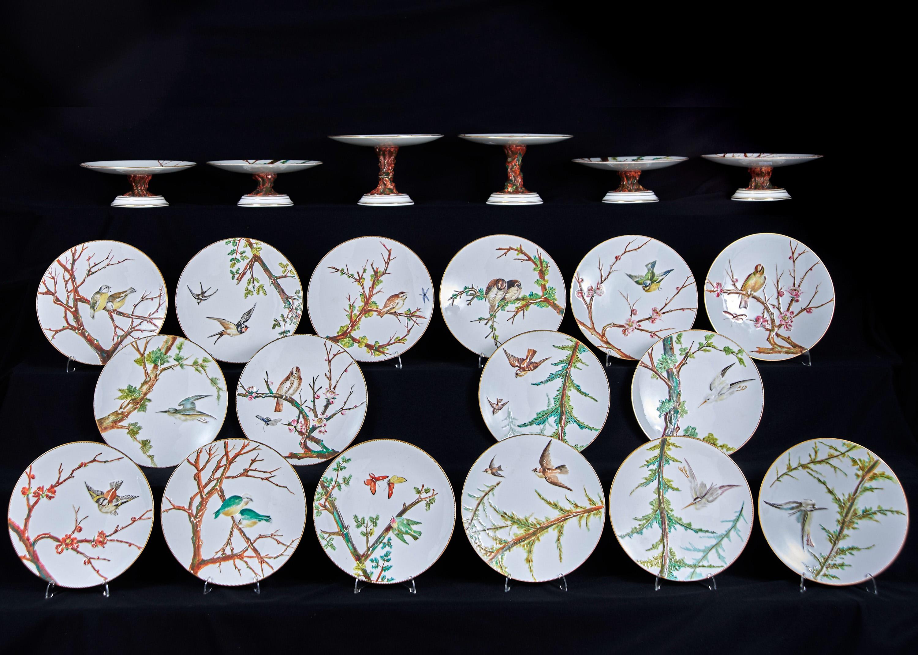 An outstanding and rare E J D Bodley relief moulded bone China dessert service, Circa 1880, enamelled with birds on branches in gilt dentil rim, the four low and two high stands on rustic foot. Each piece is impressive with flying birds and birds
