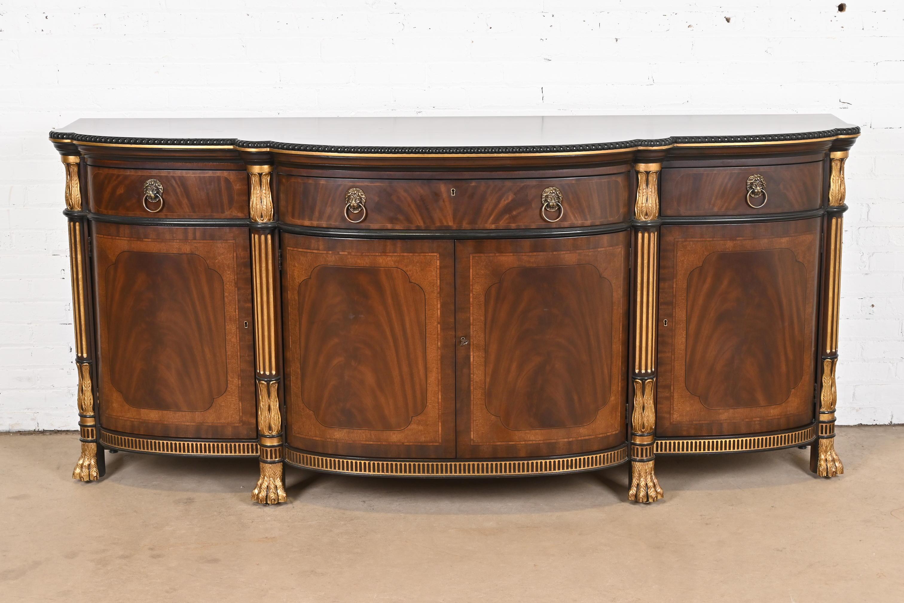 A gorgeous Regency, Neoclassical, or Empire style sideboard, credenza, or bar cabinet

By EJ Victor

USA, Circa Late 20th Century

Carved flame mahogany, with gold gilt details and lion paw feet, and original brass hardware. Cabinets lock, and key