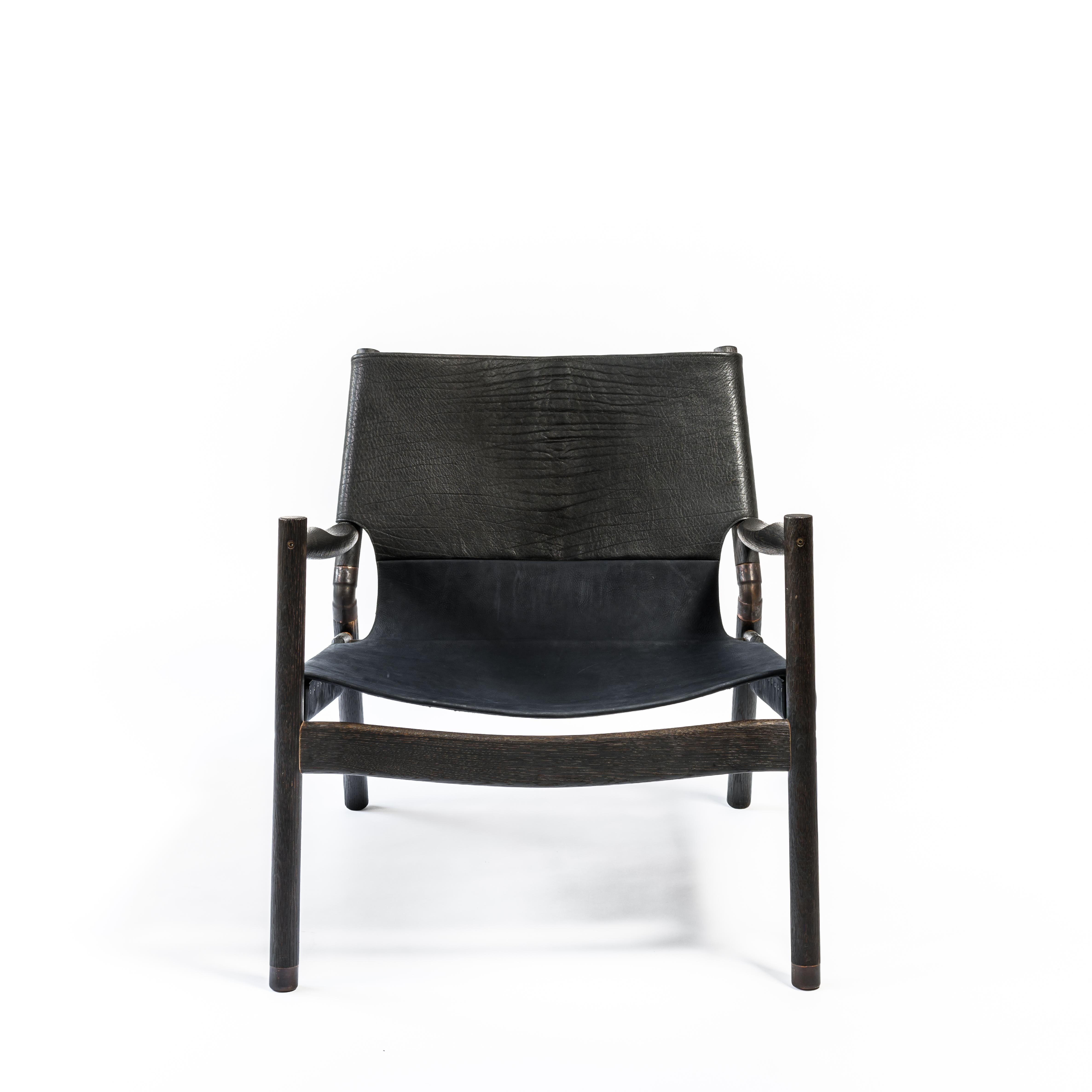 EÆ Slung leather lounge chair in shrunken Bison/ Navy nubuck leather with charred Oak frame. 
Reimagining the classic lounge chair first popularized by midcentury icons Hans Wegner and Charles and Ray Eames, designer Ben Erickson of Erickson