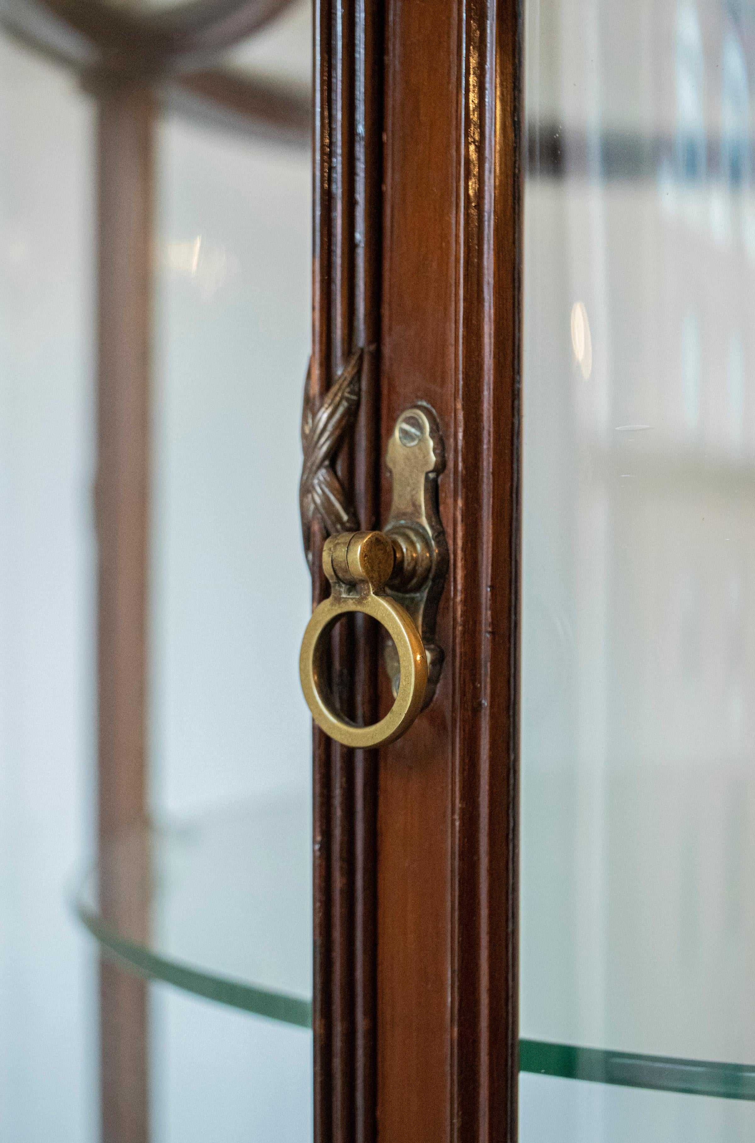 English E. Pollard & Co. Regency style mahogany vitrine / glass display cabinet, late 19th century, pagoda shaped glass paneled top over round body with three display shelves and swing door, raised on cabriole legs. 77