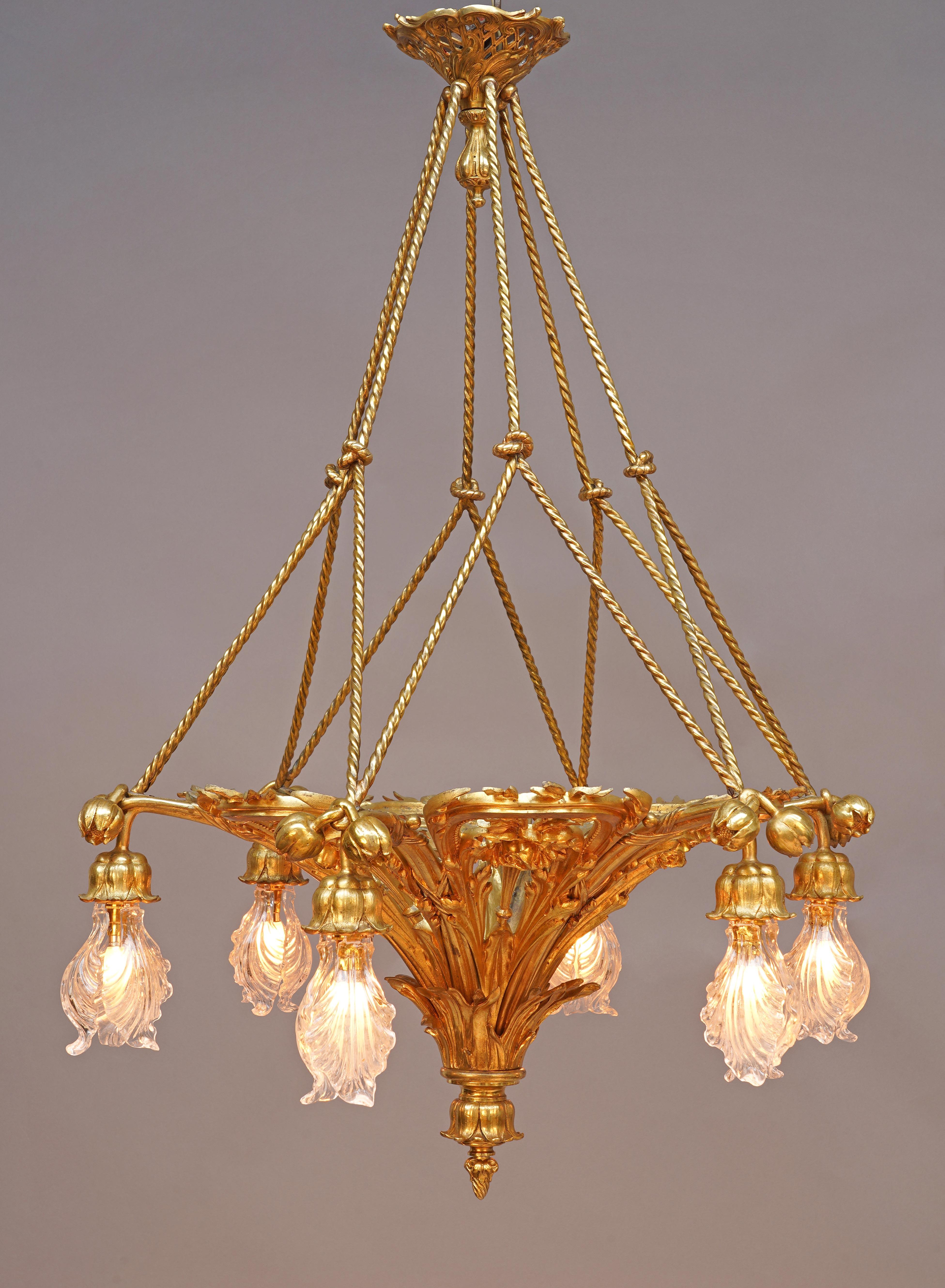 Signed E. SOLEAU PARIS

Beautiful chandelier in chiseled and gilded bronze, adorned with an abundant openwork floral decoration including poppy flowers. It illuminates with six lights formed by elegant corollas. The whole is suspended by six knotted