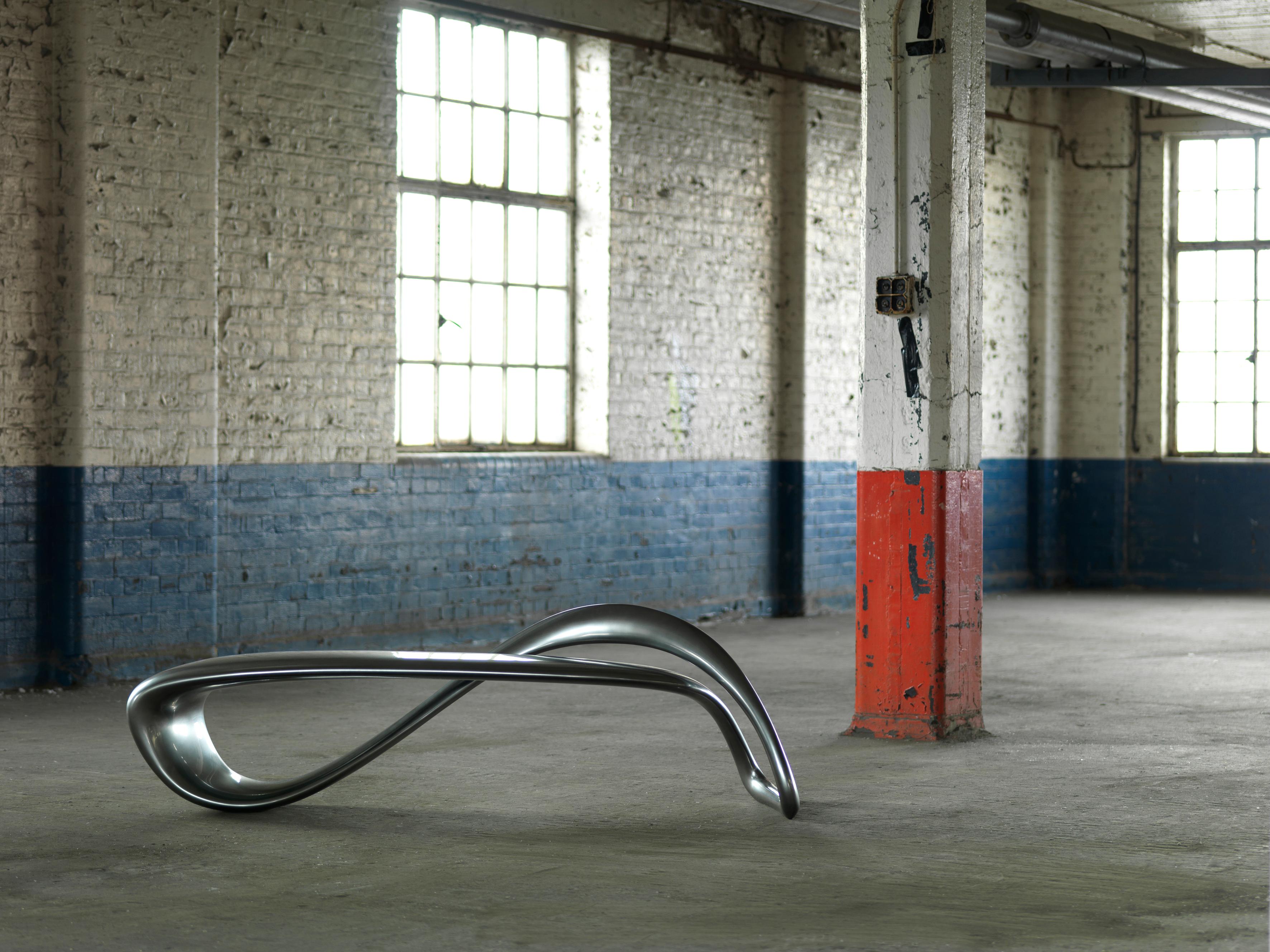 The result of exploring the possibilities of a singular line in 3D space, the E-Turn is a continuously morphing ribbon that twists and turns from seat to structure before overlapping and returning again in the configuration of a bench. The endless