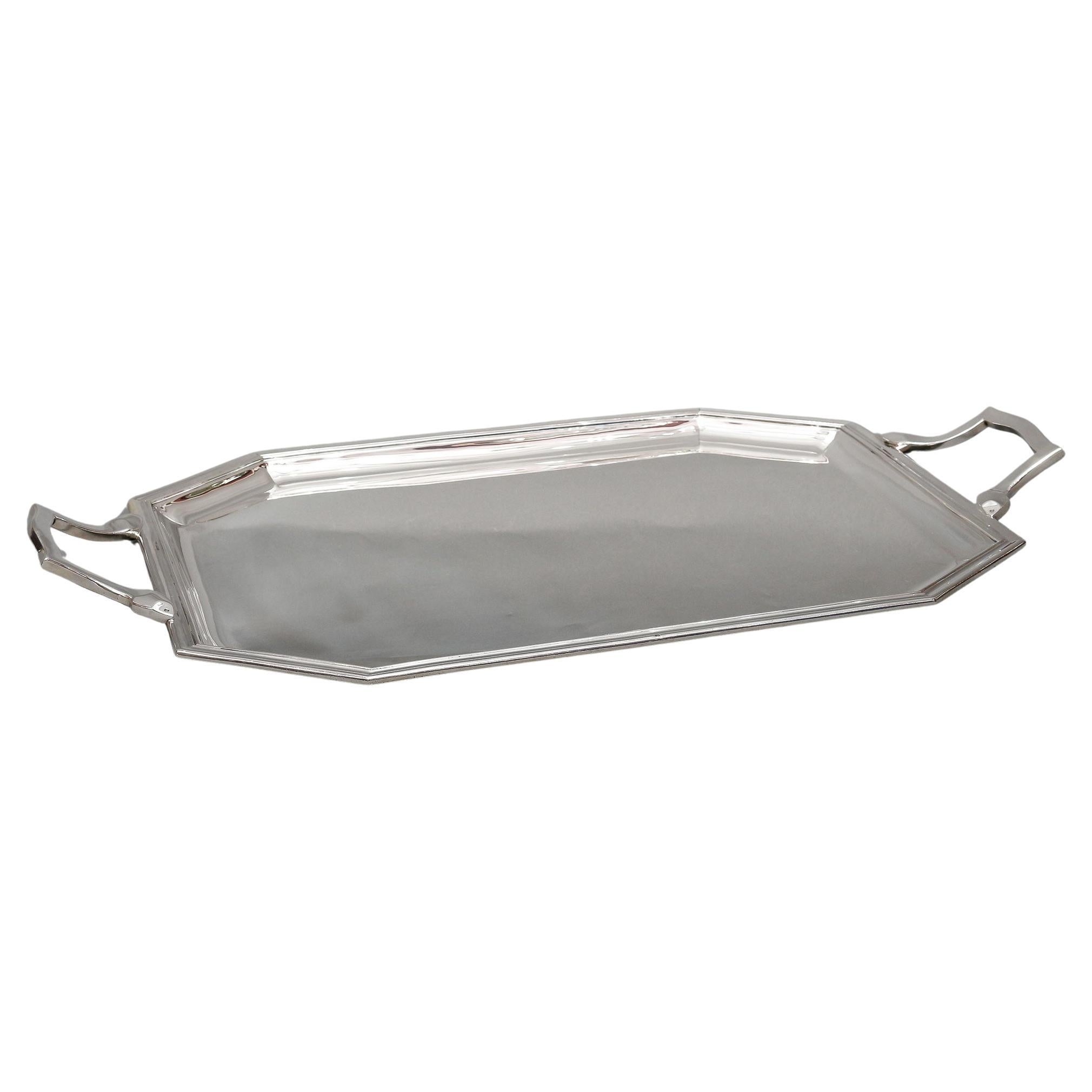Solid silver octagonal tray with wide threaded border, lowered with a hammer and flanked by two slightly raised handles.

Dimensions: length 63.5 cm – width 39 cm – height 6 cm

Material: 1st grade silver 950/°°

Weight: 2970 grams

Hallmark: