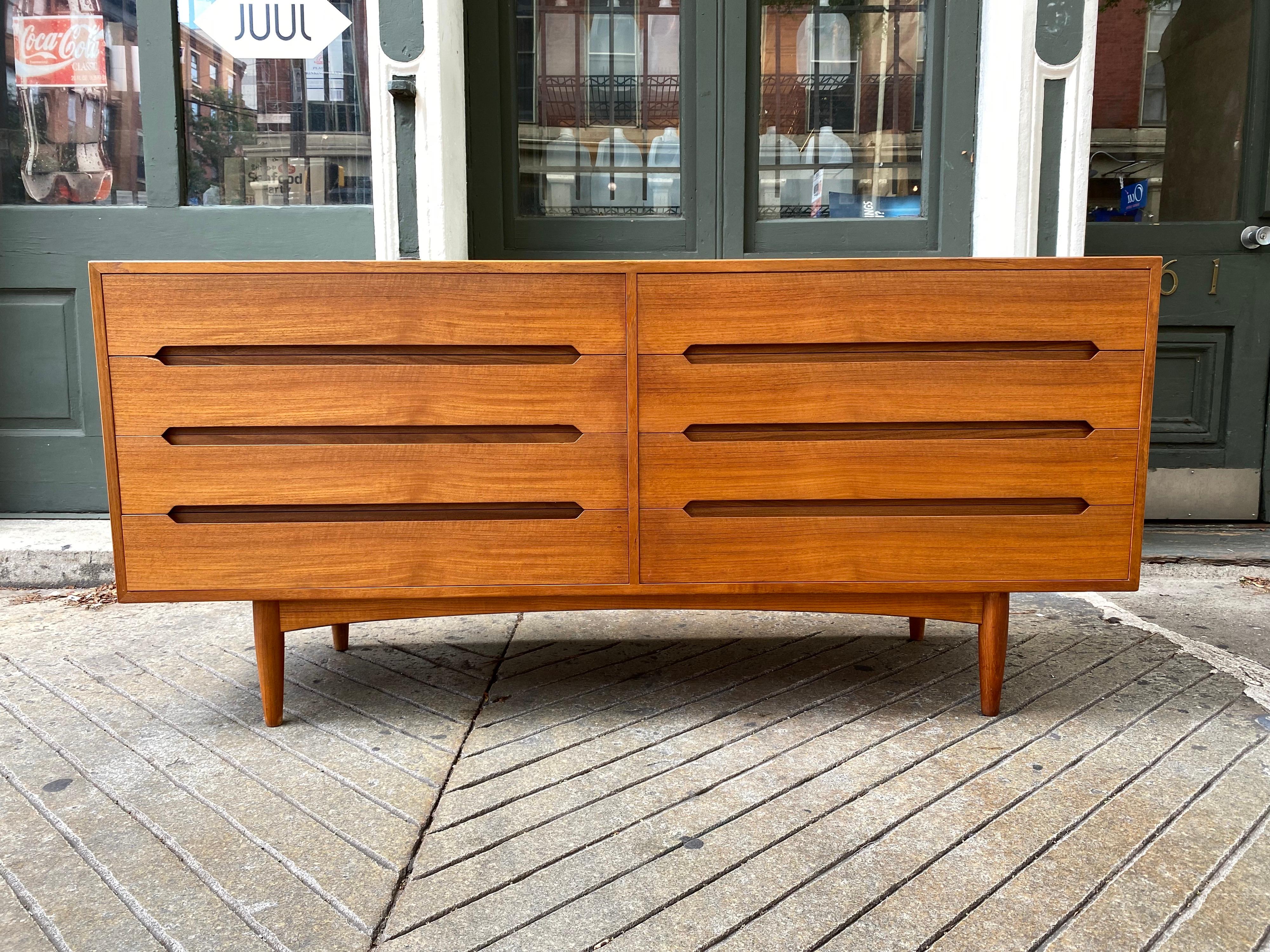 E. W. Bach Danish teak 8 drawer dresser. Recessed handles make up the design of the Cabinet. 3 Long Horizontal Bands make up the handles for 4 Drawers left and Right. Top has been refinished, very nice quality and construction! 