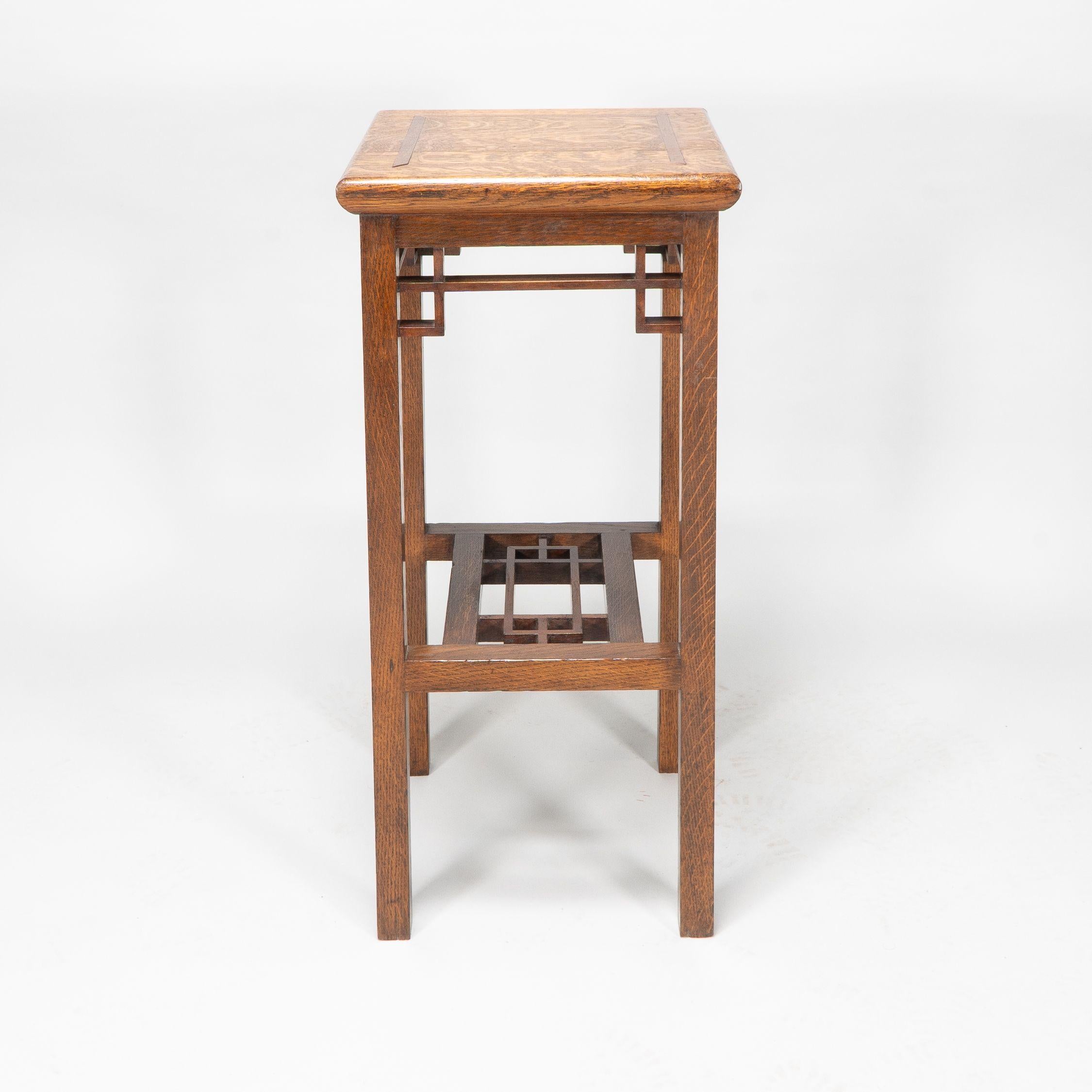 E. W. Godwin. Probably made by William Watt.
An Anglo-Japanese oak statue or plant stand with wide inlaid top, tiny dovetail joints to the lattice work supports on square legs united by a lattice under tier.