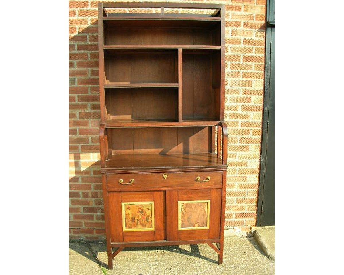 Edward William Godwin (1833-1886) per William Watt, una rara e importante libreria in noce anglo-giapponese, 1871 circa. Con maniglie in ottone e scudo a forma di scudo, l'armadio inferiore con due ante scorrevoli incastonate con pannelli dipinti