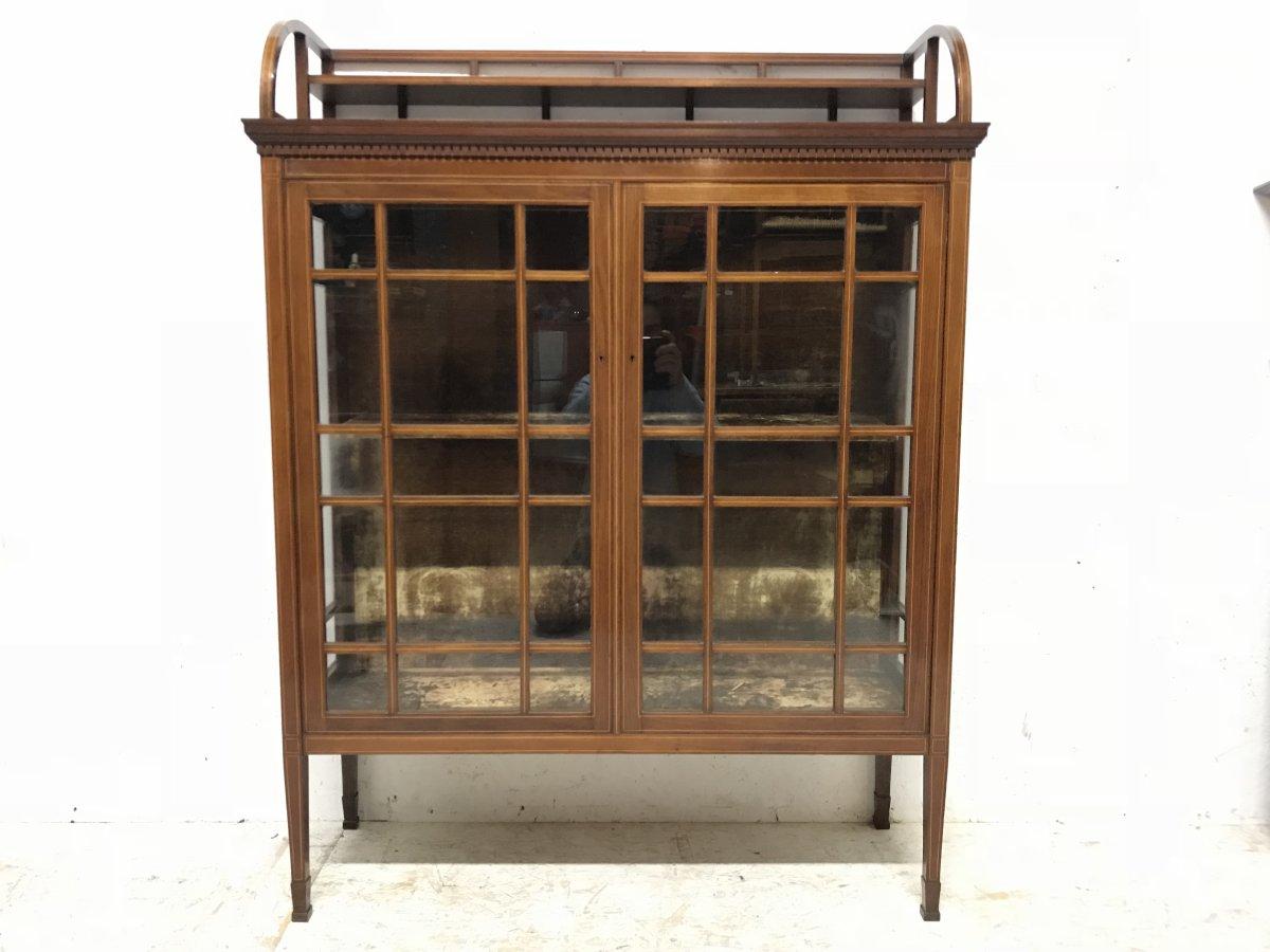Edward William Godwin. Made by Collinson & Lock.
A fine quality Anglo Japanese mahogany and astragal glazed cabinet with satinwood line inlay.
The upper gallery with semi-circular sides supporting a half stepped shelf, with vertical staggered