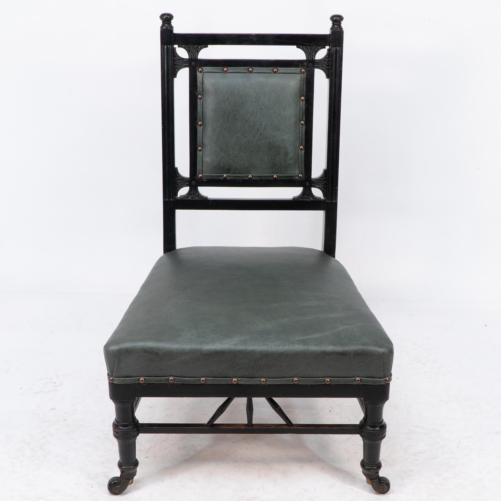E W Godwin style of, an Anglo-Japanese nursing chair with subtle carved details to the back, turned front legs united by a lower gallery to the front and sides with three angled turnings to each.
Professionally re-upholstered in a quality leather.