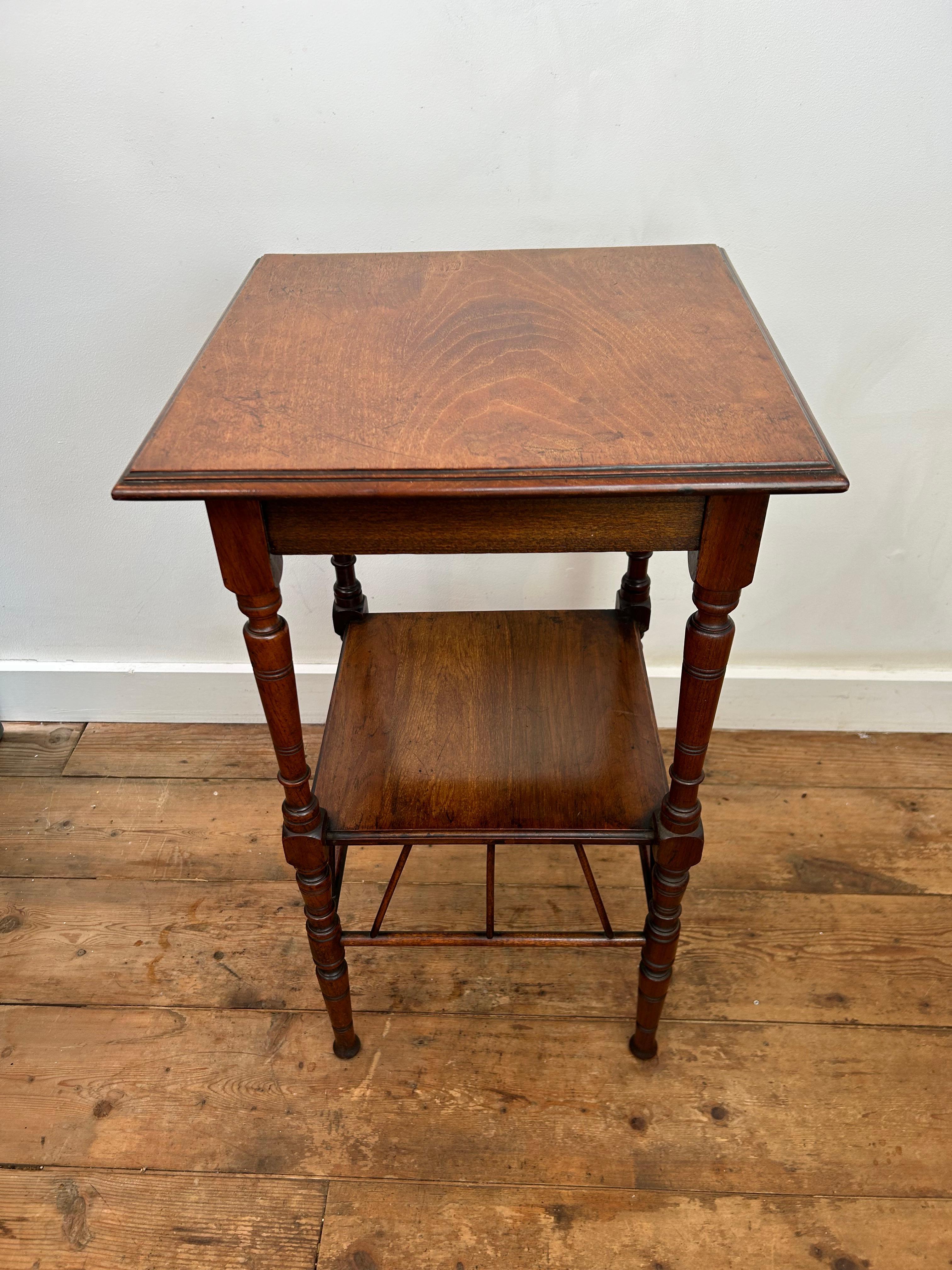 E W Godwin side table circa 1880 in walnut with a moulded top, elegant turned legs and a lower shelf supported by fine angled brackets, the table is in very good condition.