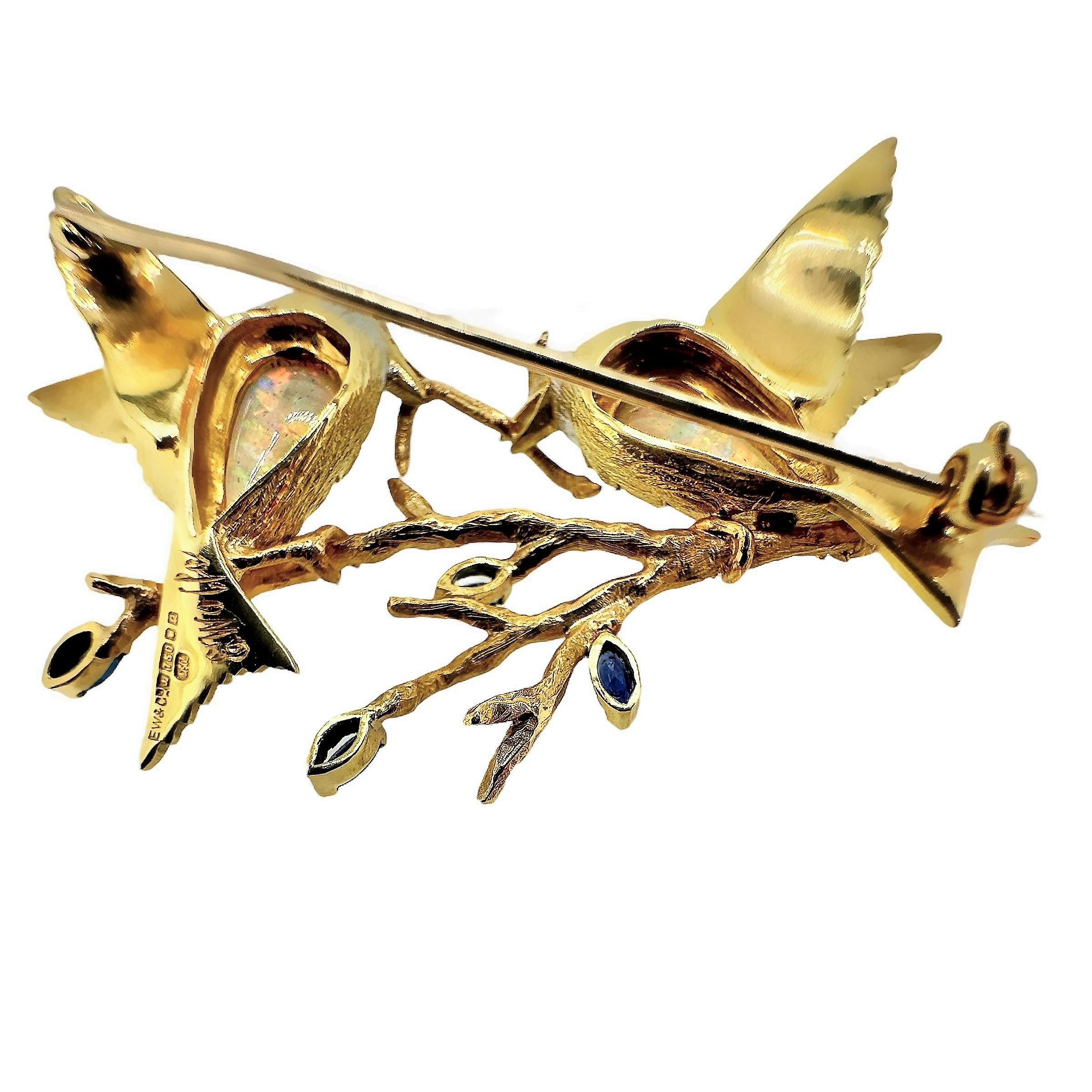 This extremely well detailed E. Wolfe signed aviary brooch, from the workshop of the well respected English Jeweler, depicts two birds on a branch either sharing or competing for a hapless worm. Extreme attention has been paid to the texture of each