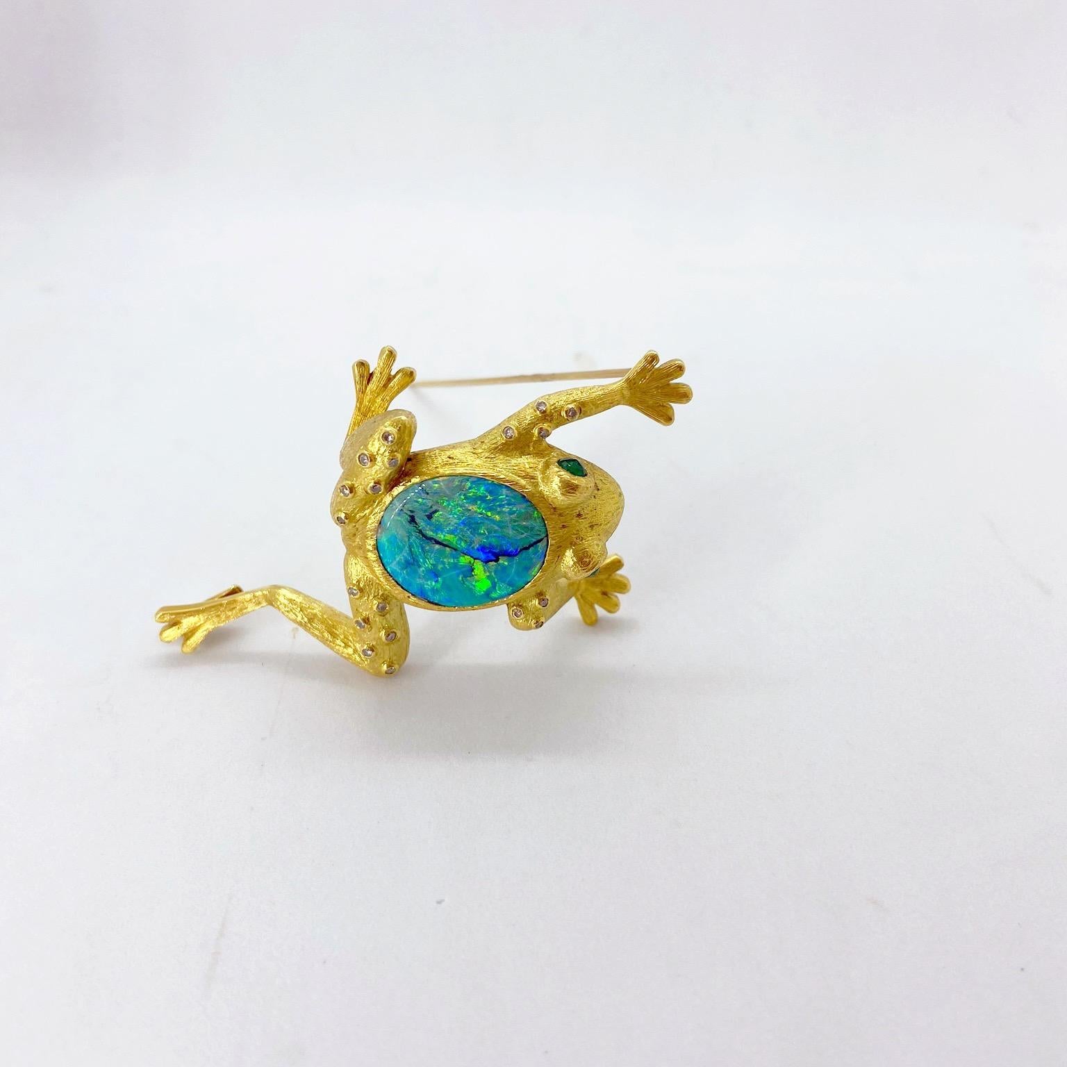 This Lovely 18 karat yellow gold frog brooch features a 9.60 carat oval black opal center, faceted round emerald eyes and a sprinkle of diamonds on the frogs arms and legs. 
Opal = 9.60 carats
Diamonds = 0.21 carats
Emeralds = 0.04 carats
Stamped