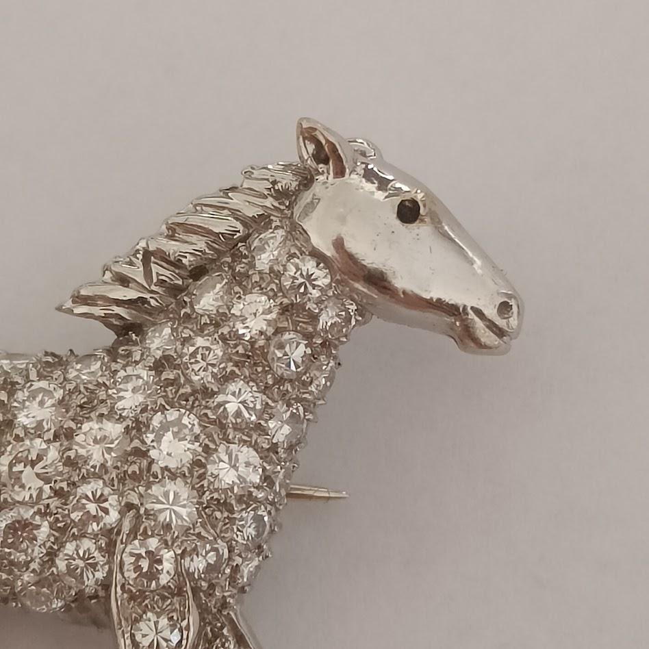 An 18k white gold brooch depicting a running horse, with diamond pave all over the body. Made by E. Wolfe & Co, London. Stamped EW & Co and 750.

Good condition, diamonds are of good quality, averaging VS-SI, I-L approximately, various