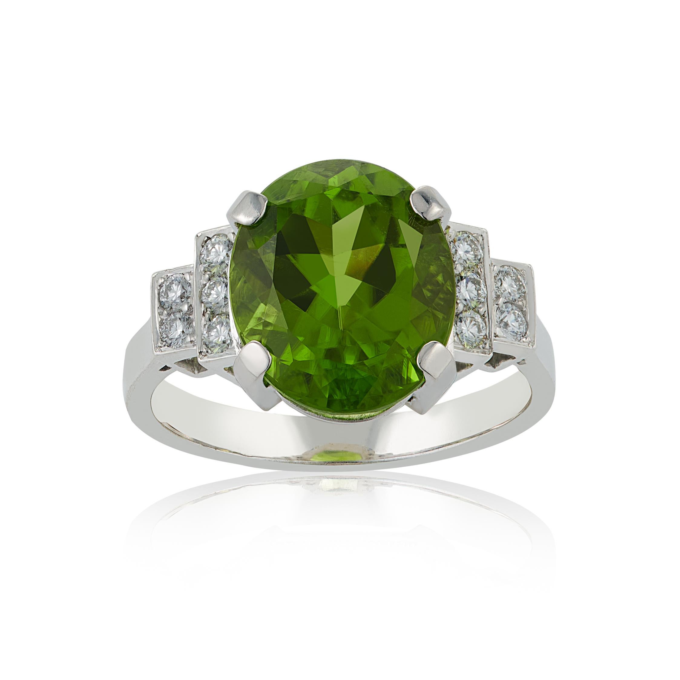 E Wolfe & Company Handmade 18ct White Gold Peridot and Diamond Cocktail Ring. The peridot centre stone weighs 7.12 carats and either side of the centre stone are pave-set diamonds set to stepped shoulders. 
The diamonds have a total weight of .28