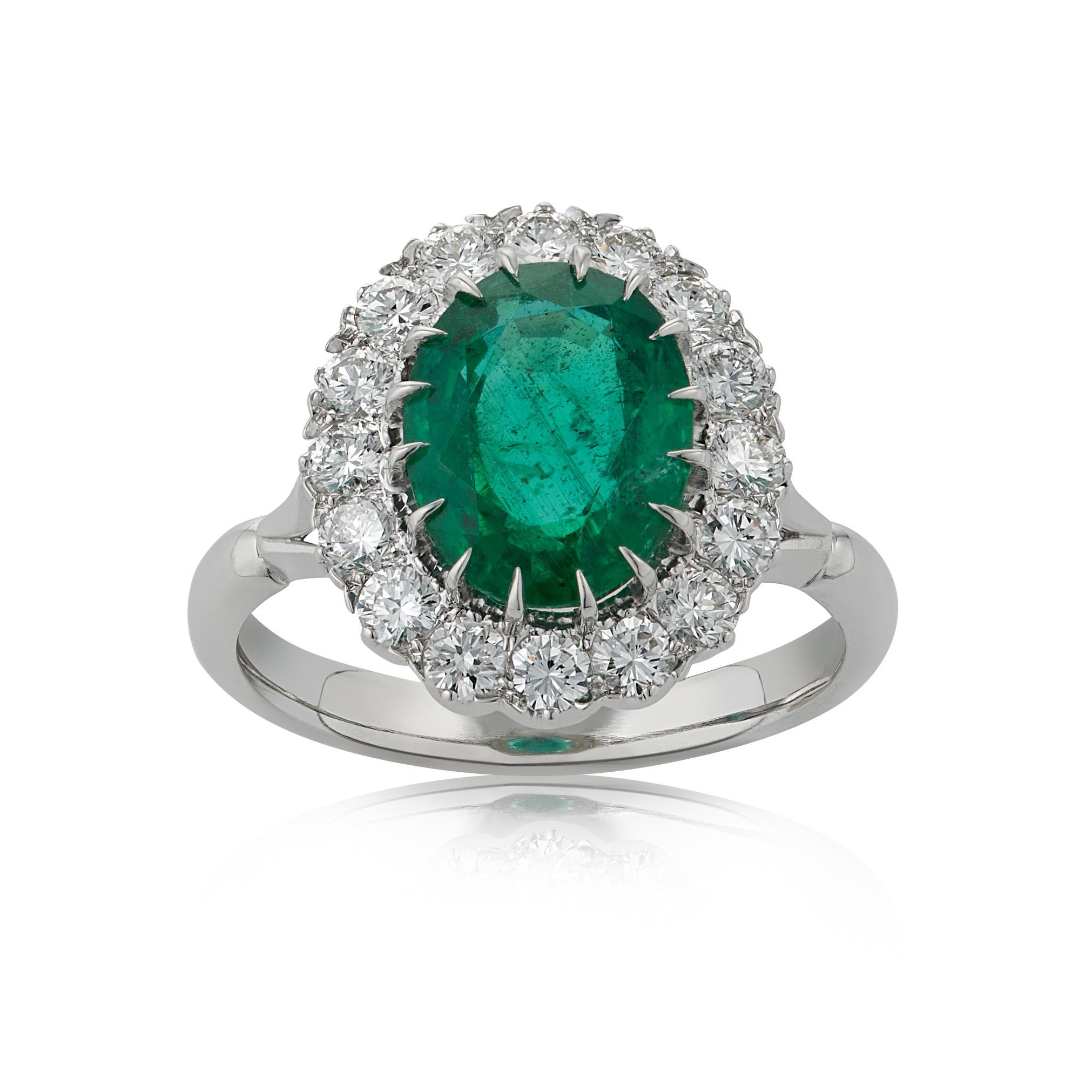 E Wolfe & Company Handmade 2.82 carat Emerald and Diamond Platinum Cluster Ring. The oval-cut emerald centre stone weighs 2.82 carats and is surrounded by 16 round brilliant diamonds which collectively weigh .77 carats. The diamonds are of G colour