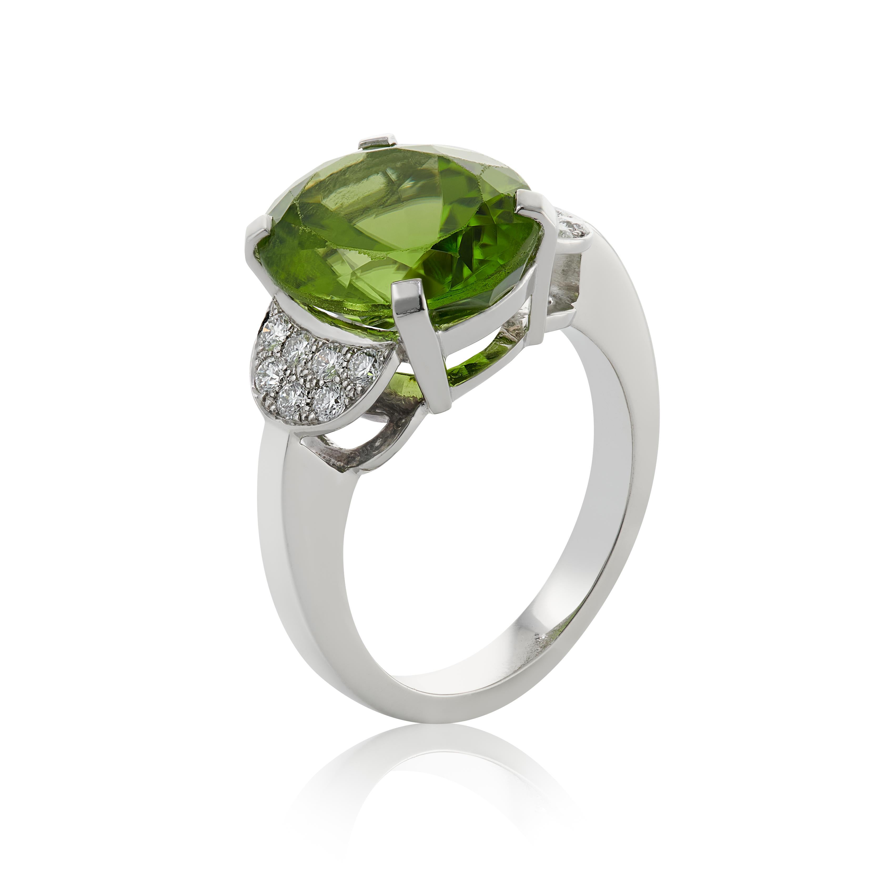 E Wolfe & Company Handmade 7.12 carats oval-cut Peridot and Diamond Platinum Cluster Ring. The oval-cut peridot centre stone weighs 7.12 carats and has round brilliant diamonds pave-set to the shoulders either side which collectively weigh .28