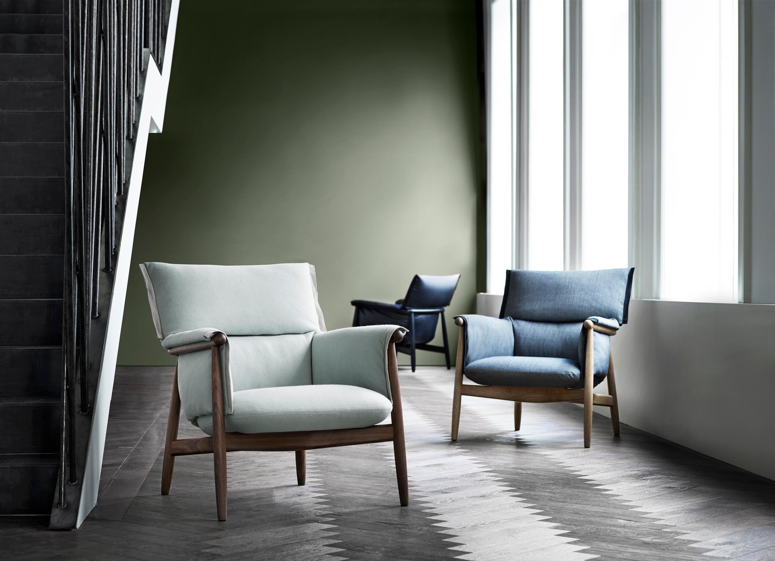 EOOS hat den E015 Embrace Lounge Sessel entwickelt, um höchsten Komfort zu bieten. Der Stuhl besteht aus einer durchgehend sichtbaren Holzstruktur mit einer dreiteiligen, abgerundeten Rückenlehne und charakteristischen Beinen, die den Gesamtrahmen