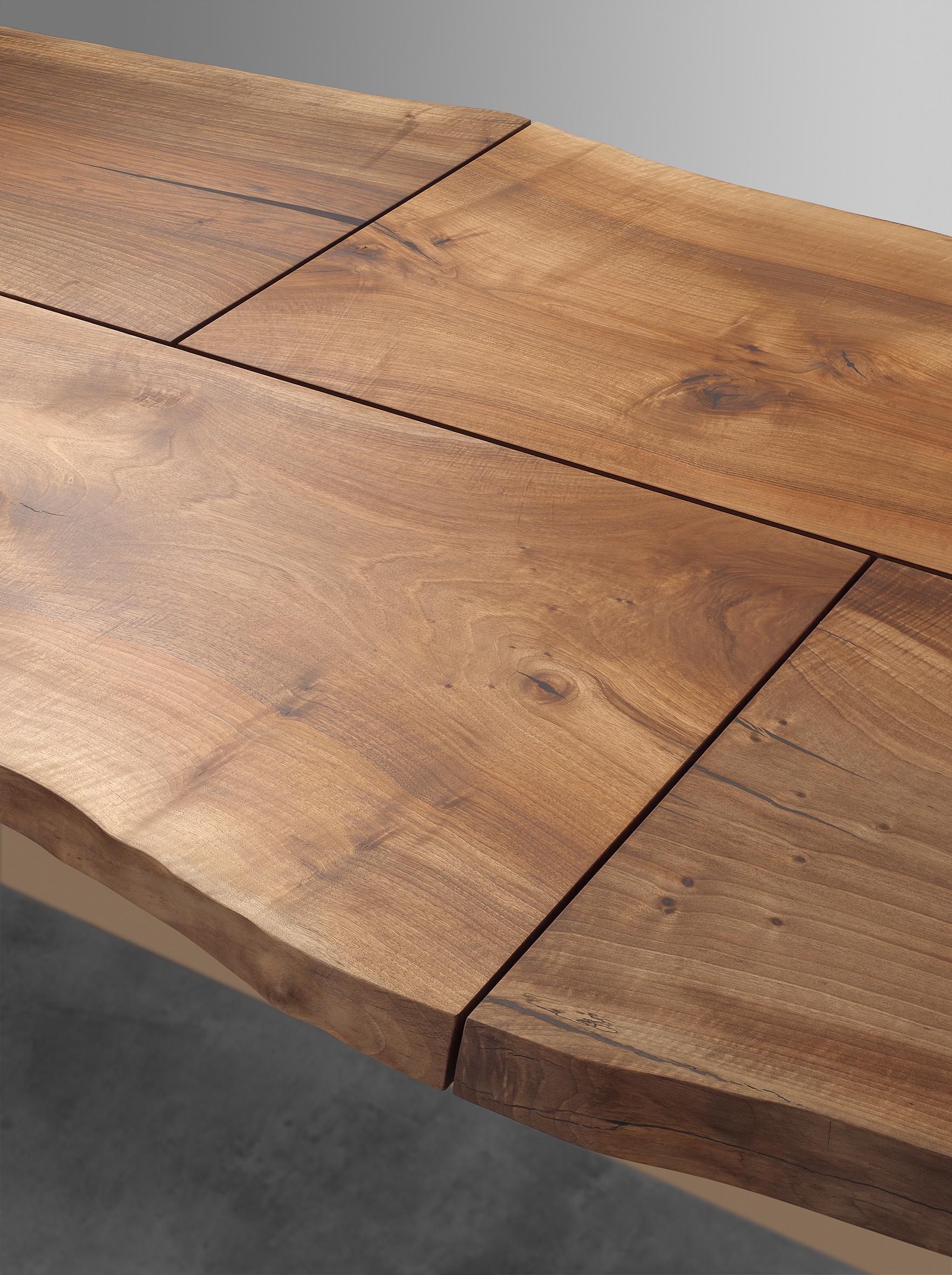 Fabriquée à partir d'un seul tronc de noyer européen choisi individuellement, la table Trunk II de 4100 MM (161 3/8 INCH) de long souligne la fusion de l'architecture et de l'artisanat. Flottant sur une base sculpturale en laiton massif, le plateau