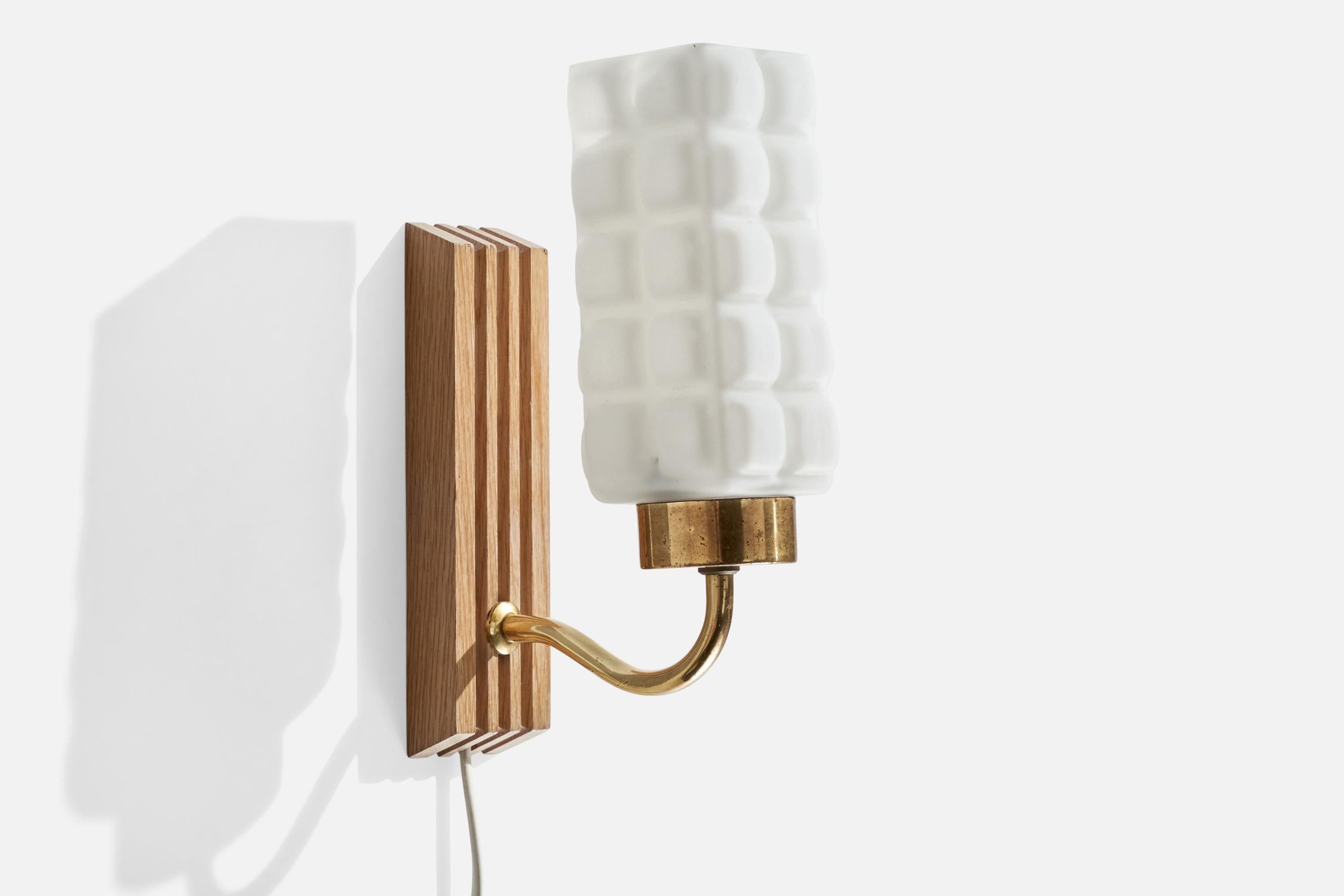 A brass, oak and white opaline glass wall light designed and produced by E.A.E. Sweden, c. 1950s.

Overall Dimensions (inches): 9.125 ” H x  3” W x  6“D

Back Plate Dimensions (Inches):  7.125” H x 2” W x .875” D

Bulb Specifications: E-14
