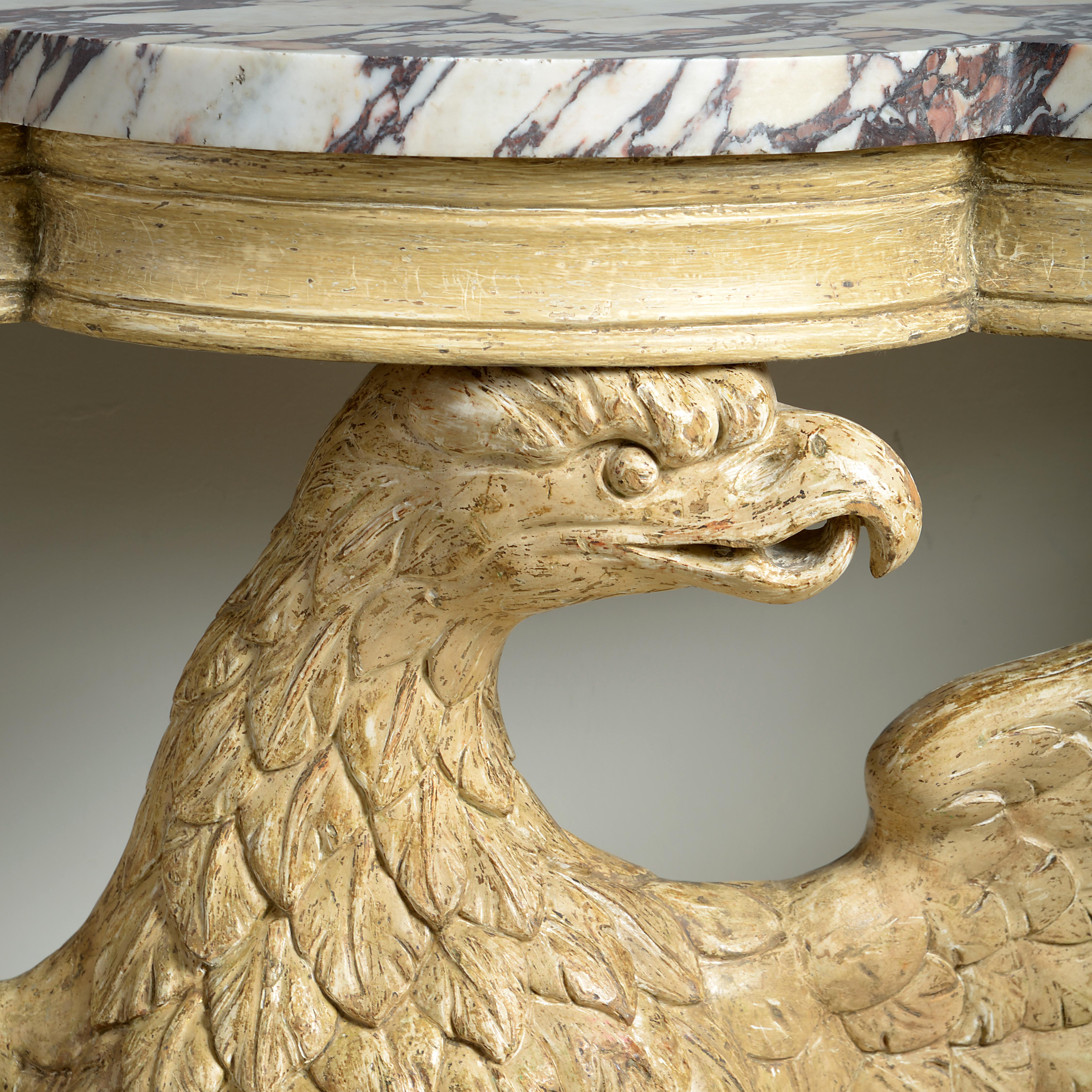 A stone-painted carved eagle console table. The eagle and rockwork base circa 1740, the moulded frieze circa 1835.

The original stone-colored paint was revealed under a layer of late-Victorian bronzing and a layer of early 19th century gilding.