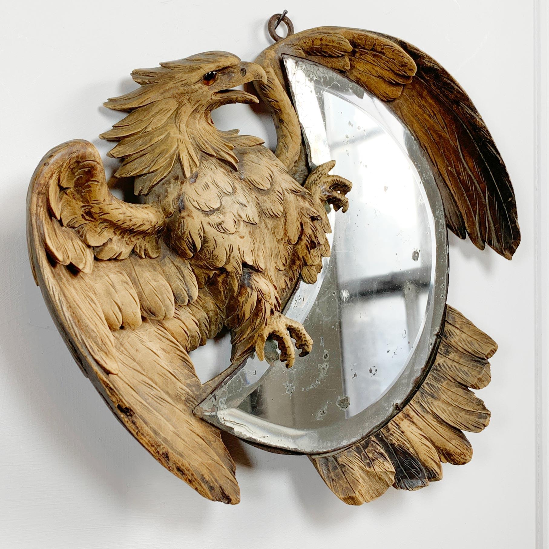 Fantastic hand carved Eagle gripping a crescent bevelled mirror, dating to the late 19th century, Swiss Black Forest. The carving still has its’ original glass eye and is in exceptional condition

There are a couple of minor losses to the claws,