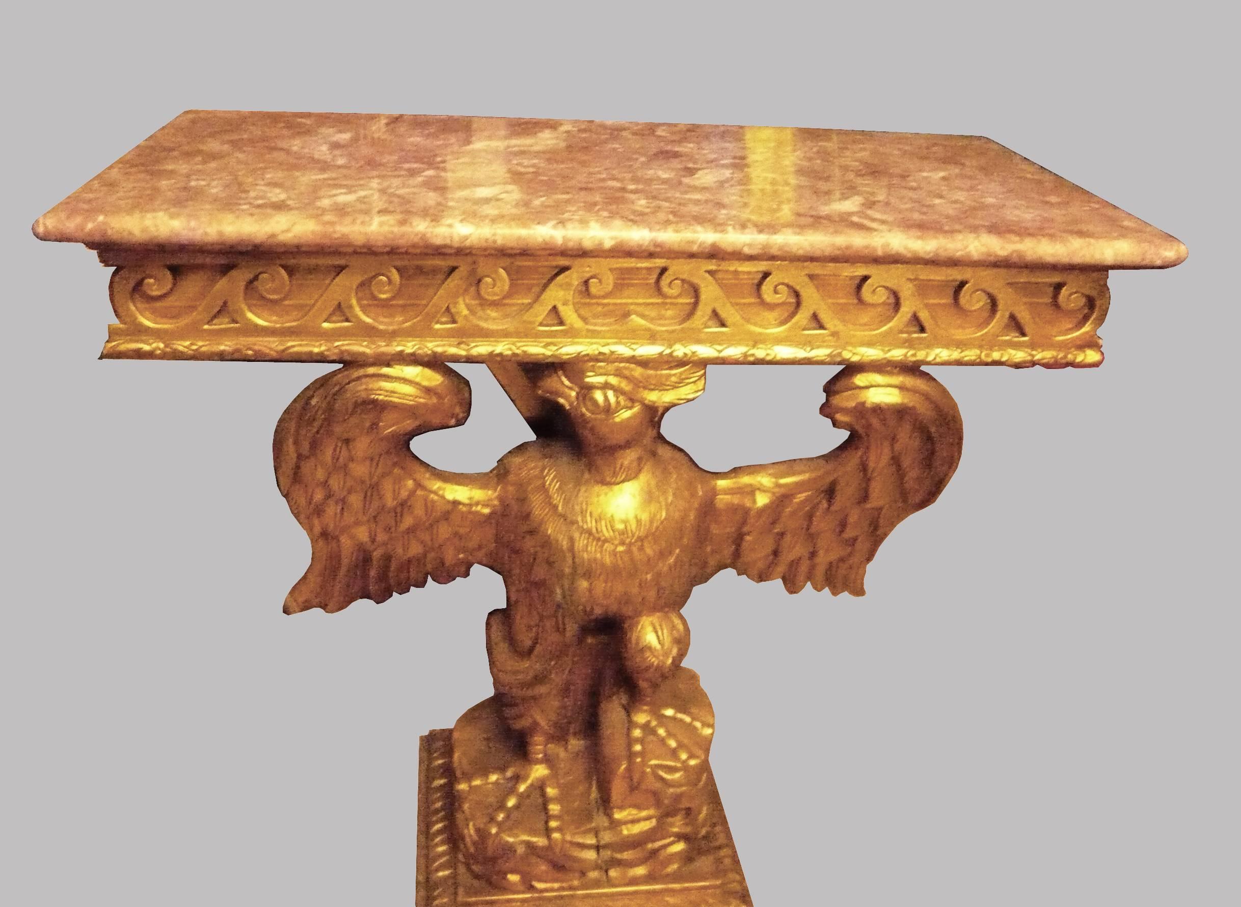 Elegant pair of French giltwood consoles or side tables with beautiful carved and rose and white marble top hold by the wings of power golden eagles base.
