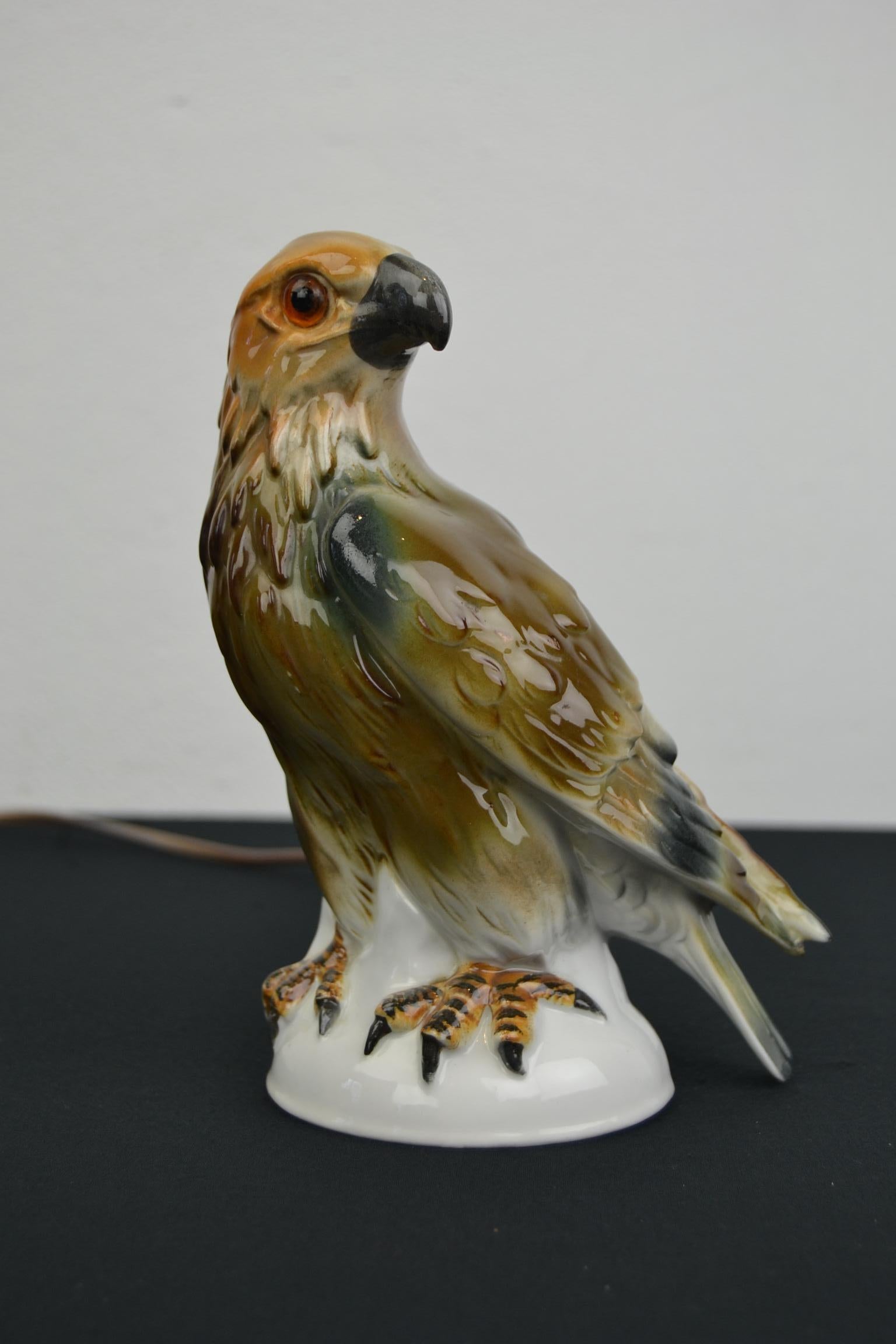 Great looking perfume lamp in the shape of an eagle bird. 
A perfume lamp of a porcelain eagle sculpture with glass eyes.
This animal statue, animal light, bird lamp dates from the Art Deco period where great colors were used.
It's a little table