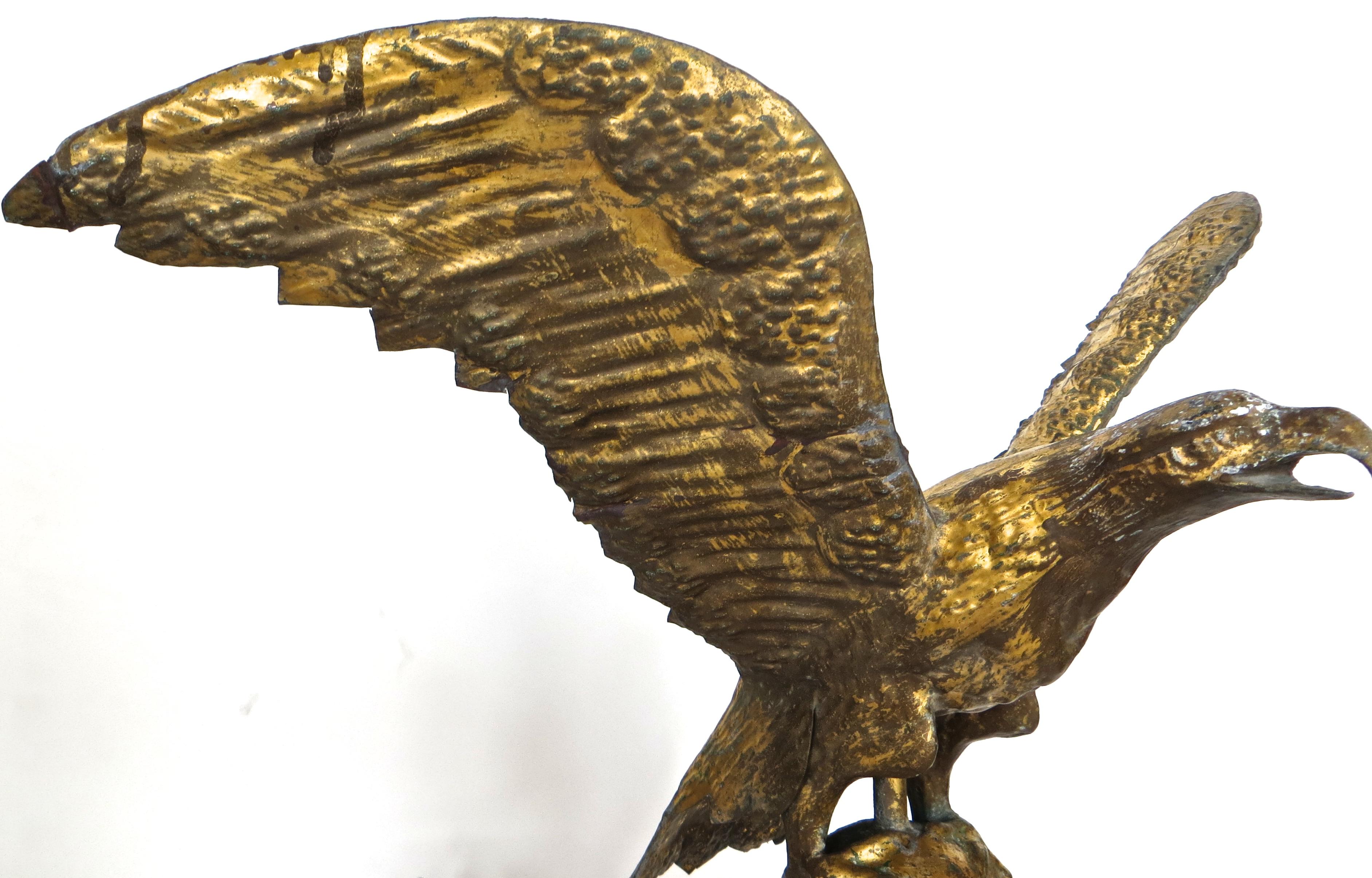 Outstanding example of a turn of the century gilded copper weathervane of an eagle with outstretched wings, sitting atop a ball; more than likely manufactured by the Puritan Ironworks Company of Boston, Massachusetts, noted for fine quality goods.