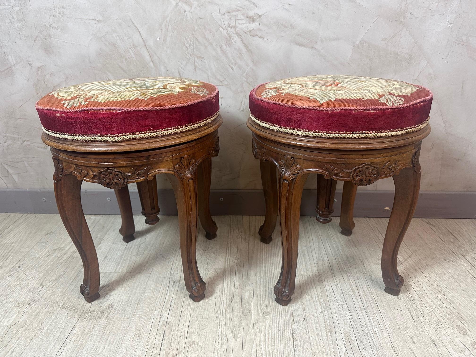 Very beautiful and rare pair of Louis XV style swivel and adjustable piano stools dating from the beginning of the 20th century. 
Made of walnut, hand carved details, curved base. Covered with a hand embroidered fabric representing flowers. Gold