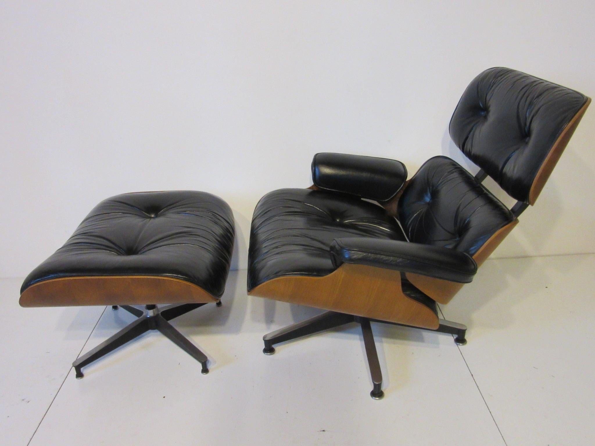 The classic iconic Eames lounge chair and ottoman with walnut frame, soft black leather upholstered cushions and cast aluminum legs. Retains the manufactures tags to each piece by the Herman Miller furniture company , measurement for the ottoman is