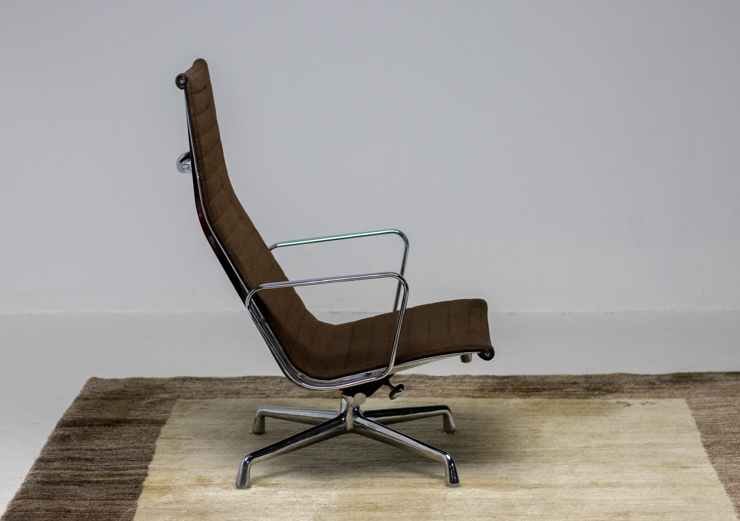 Eames Aluminium Gruppe Lounge Stuhl EA 124 zweifarbig dunkelbraun Hopsak Stoff, hergestellt von Herman Miller. Der Stuhl ist aus verchromtem Aluminium gefertigt, drehbar und hat einen verstellbaren Kippmechanismus. 
Begehrenswerte, sehr frühe