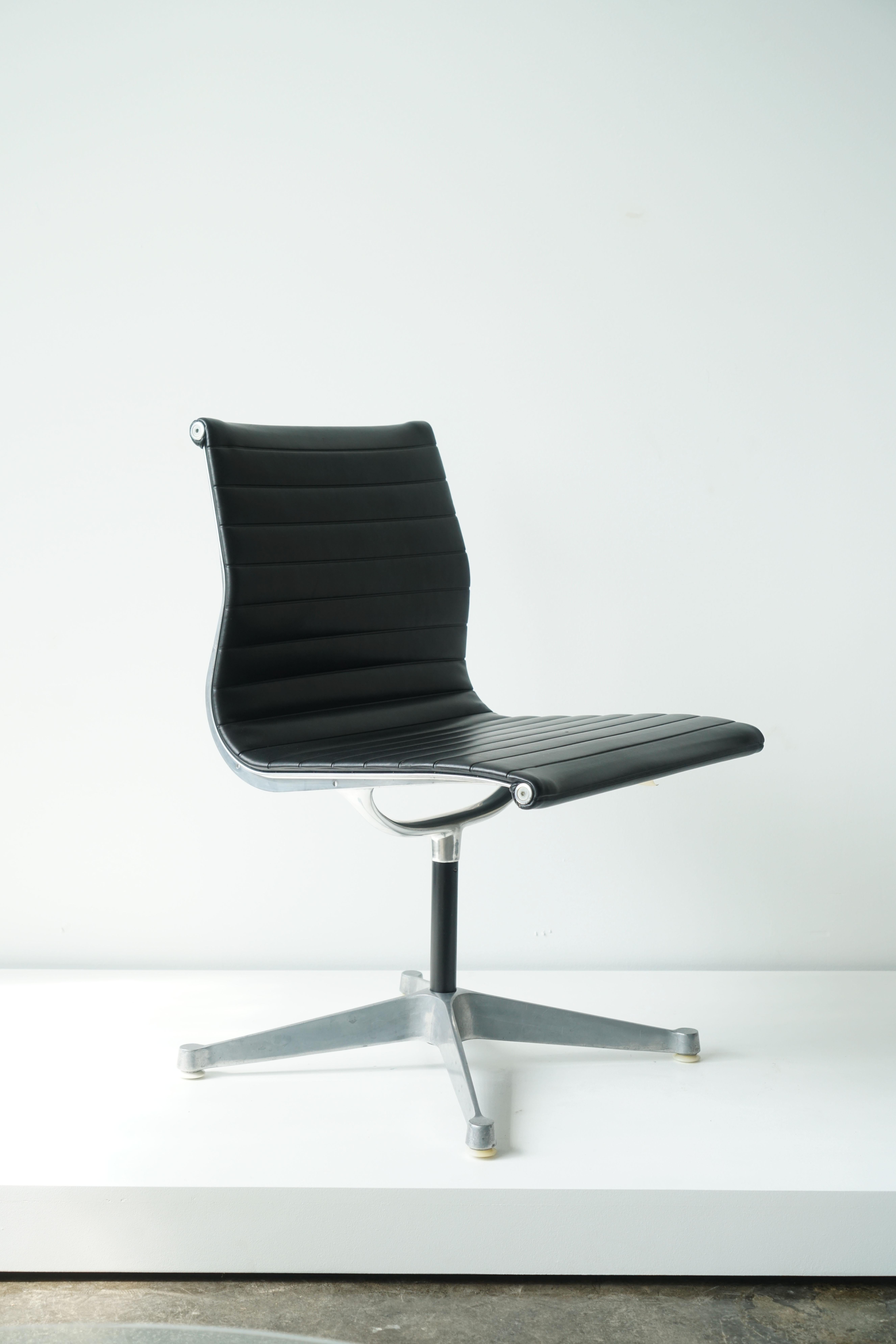 Aluminum Group Side Chair by Charles and Ray Eames for Herman Miller
circa 1970s
Fixed chair height with 4-star base
Black vinyl upholstery

The prototypical 