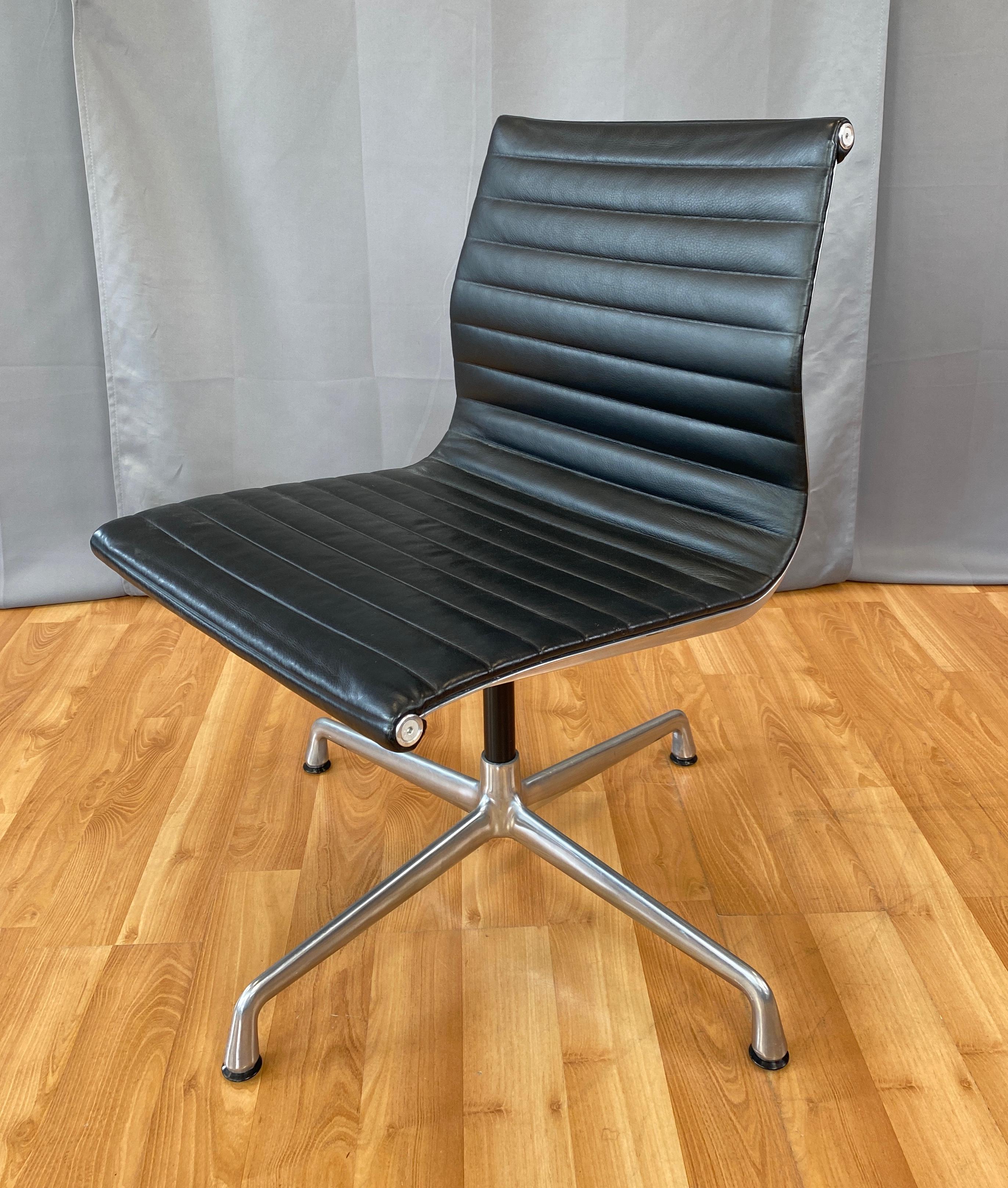 Offered here is a Eames aluminum group armless side chair. 
Has an Aluminum frame and Black leather upholstery. 
First designed in 1958, this one is circa 2000's.
