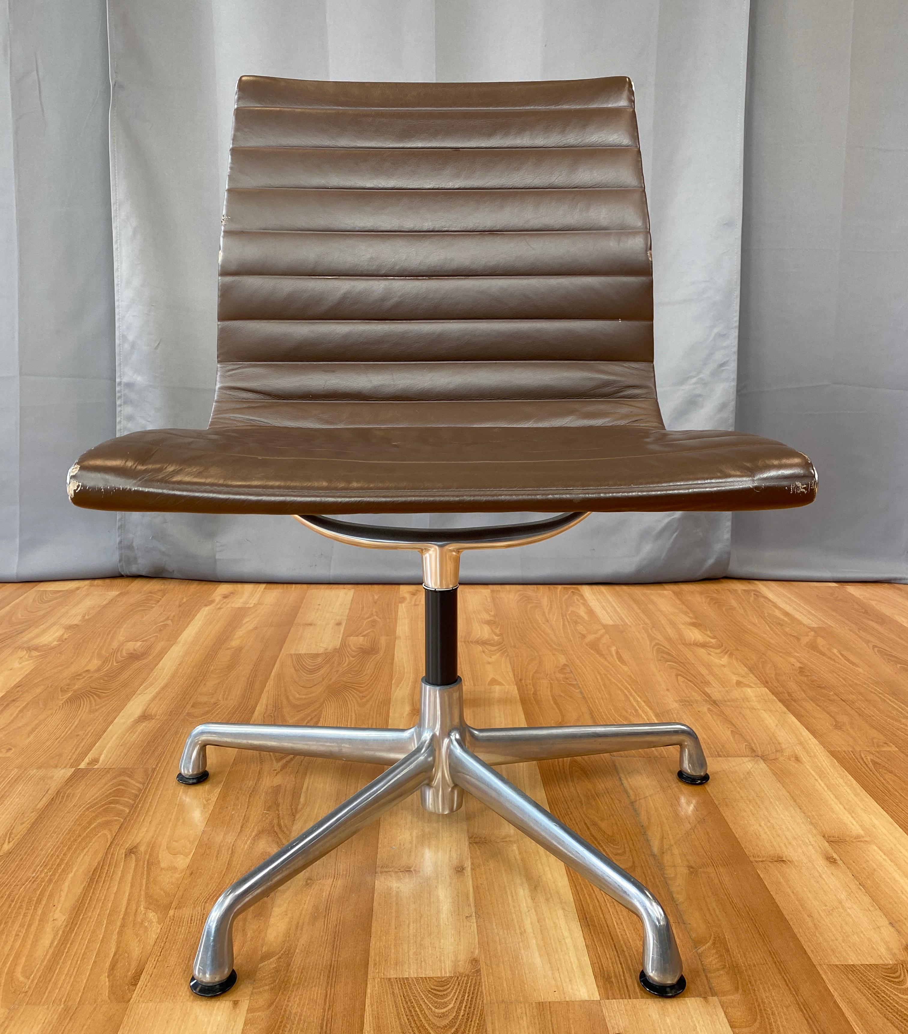 Offered here is a Eames aluminum group armless side chair. 
Has an aluminum frame and brown leather upholstery. 
First designed in 1958, this one is circa 2000's.