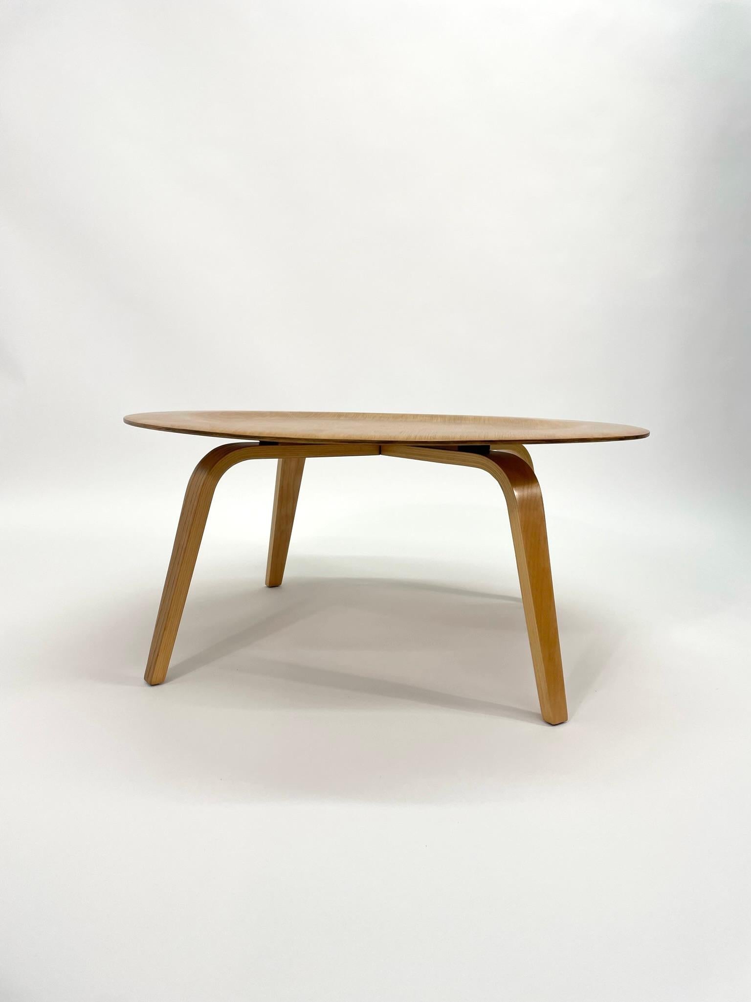 This 3rd Generation Eames CTW Coffee Table for Herman Miller was made in 1950. This table consists of a circular five-layer plywood top, sitting upon four matching legs of bent plywood to a near 90 degrees. CTW was the abbreviated name of the Coffee