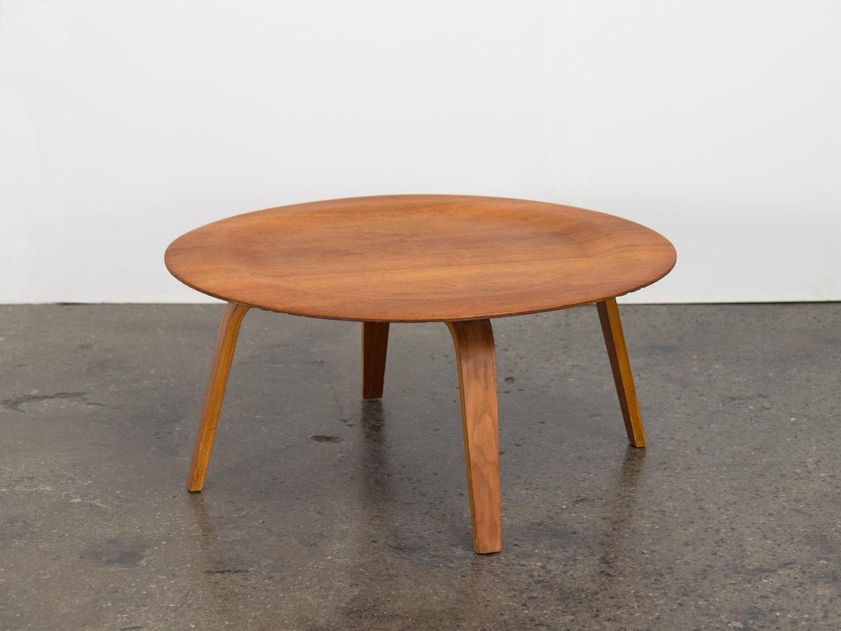 Vintage Eames CTW coffee table in walnut, designed by Charles and Ray Eames. Timeless lightweight design with clean silhouette, sure to bring balance to living room elements. The subtle indented surface is made of 5 layers of plywood and rests on