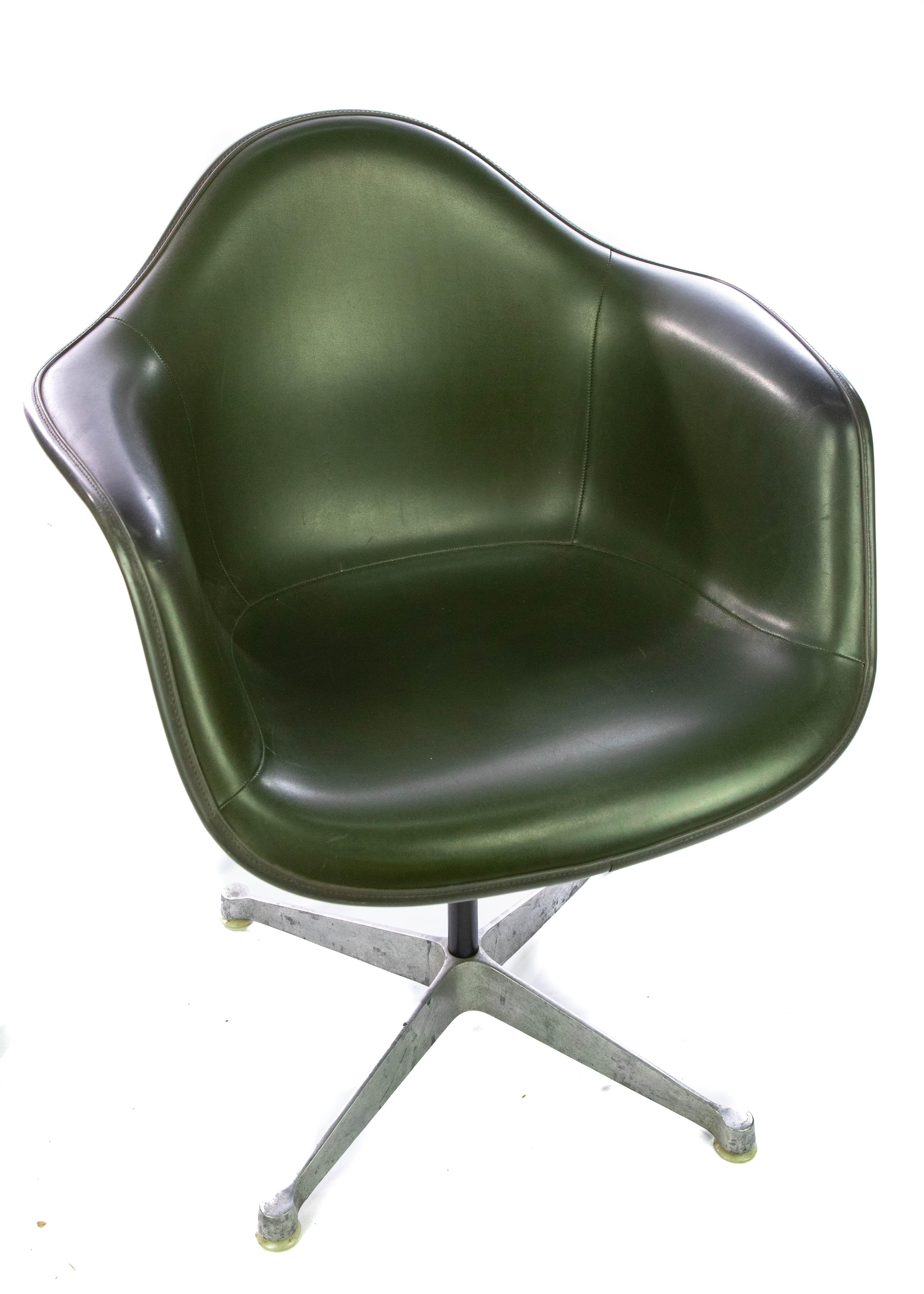 Offering this stunning Eames fiberglass armchair for Herman Miller. This dark green chair will not disappoint! Standing on a star base the fiberglass and upholstery are in almost perfect condition. Great as a side chair or an office chair! All