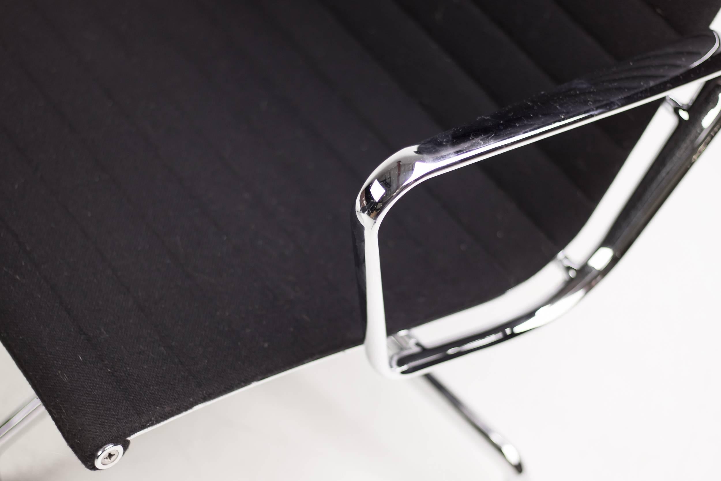 Two matching Eames aluminum group chairs (EA 124) in black fabric (Hopsak), manufactured by Vitra. 
Chromed aluminum with swivel and adjustable tilting mechanism. 

 
 