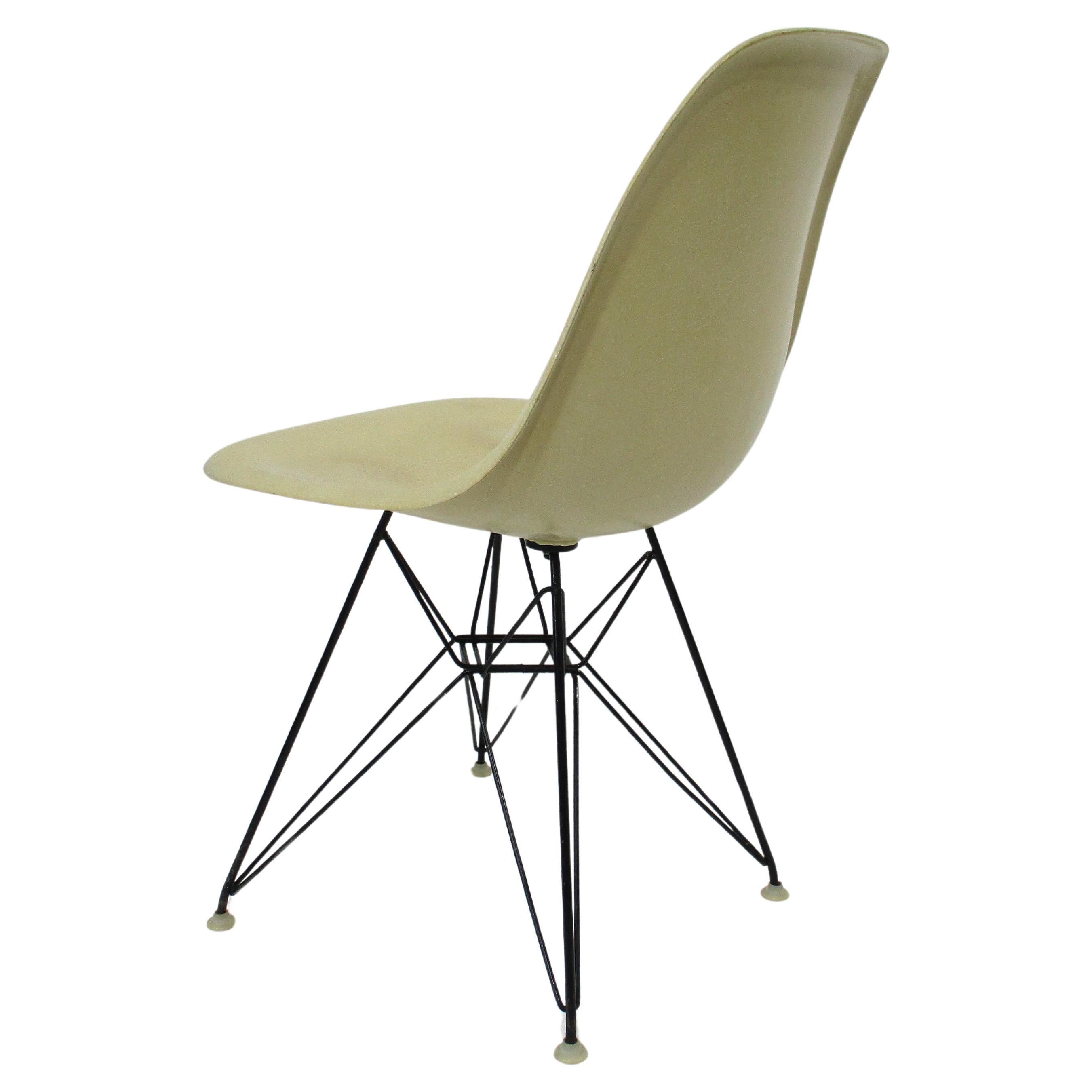 A parchment cream colored fiberglass desk chair with the satin black wire Eiffel tower base . The base has nylon foot pads to protect your floors and the slim and light look has great ergonomics for long periods of comfortable sitting . Designed by