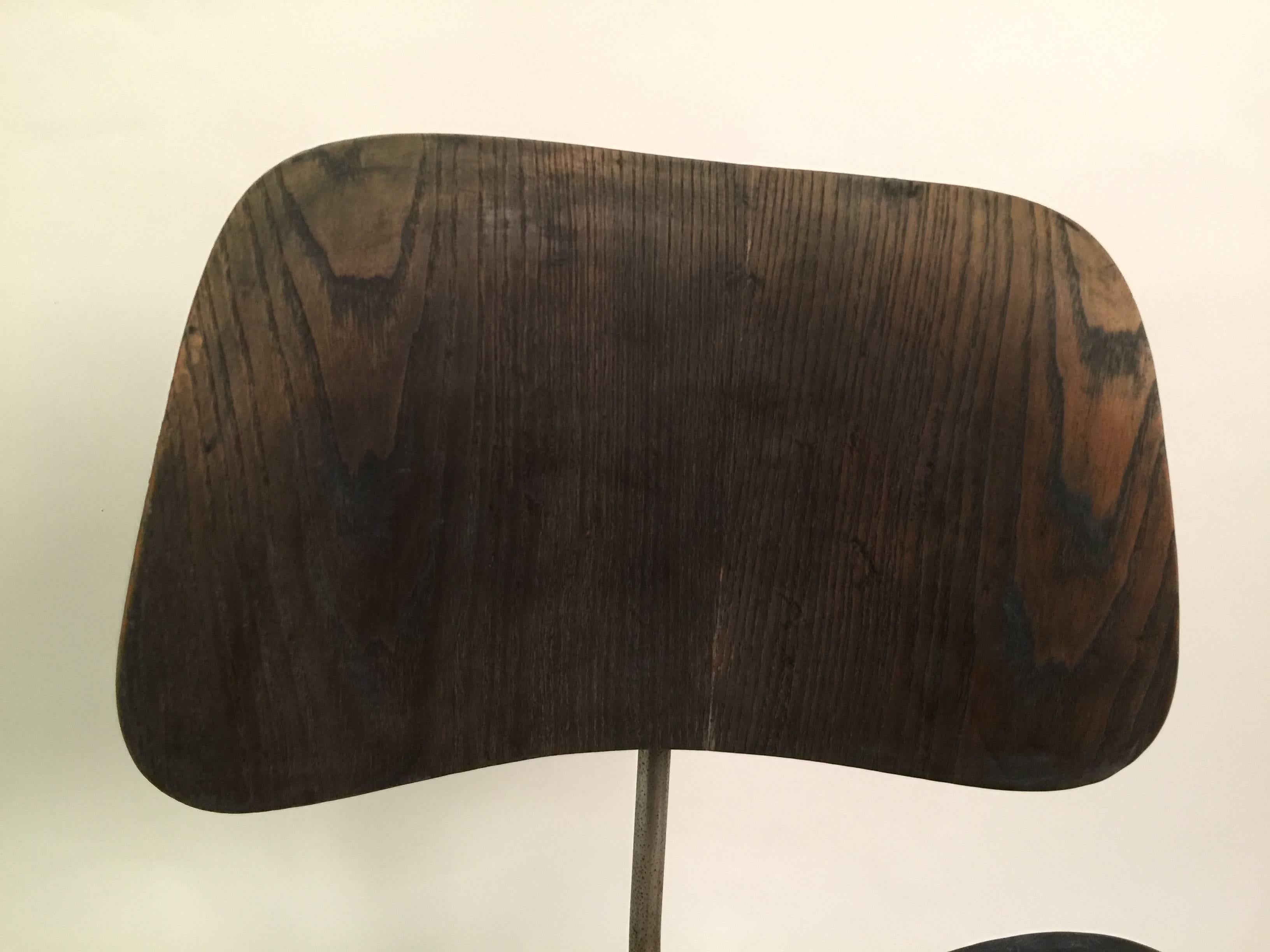 Black aniline DCM dining chair by Charles and Ray Eames. these first edition chairs were produced by Evans manufacturing and distributed by Herman Miller. Chair has labels intact fitted with new boot glides.